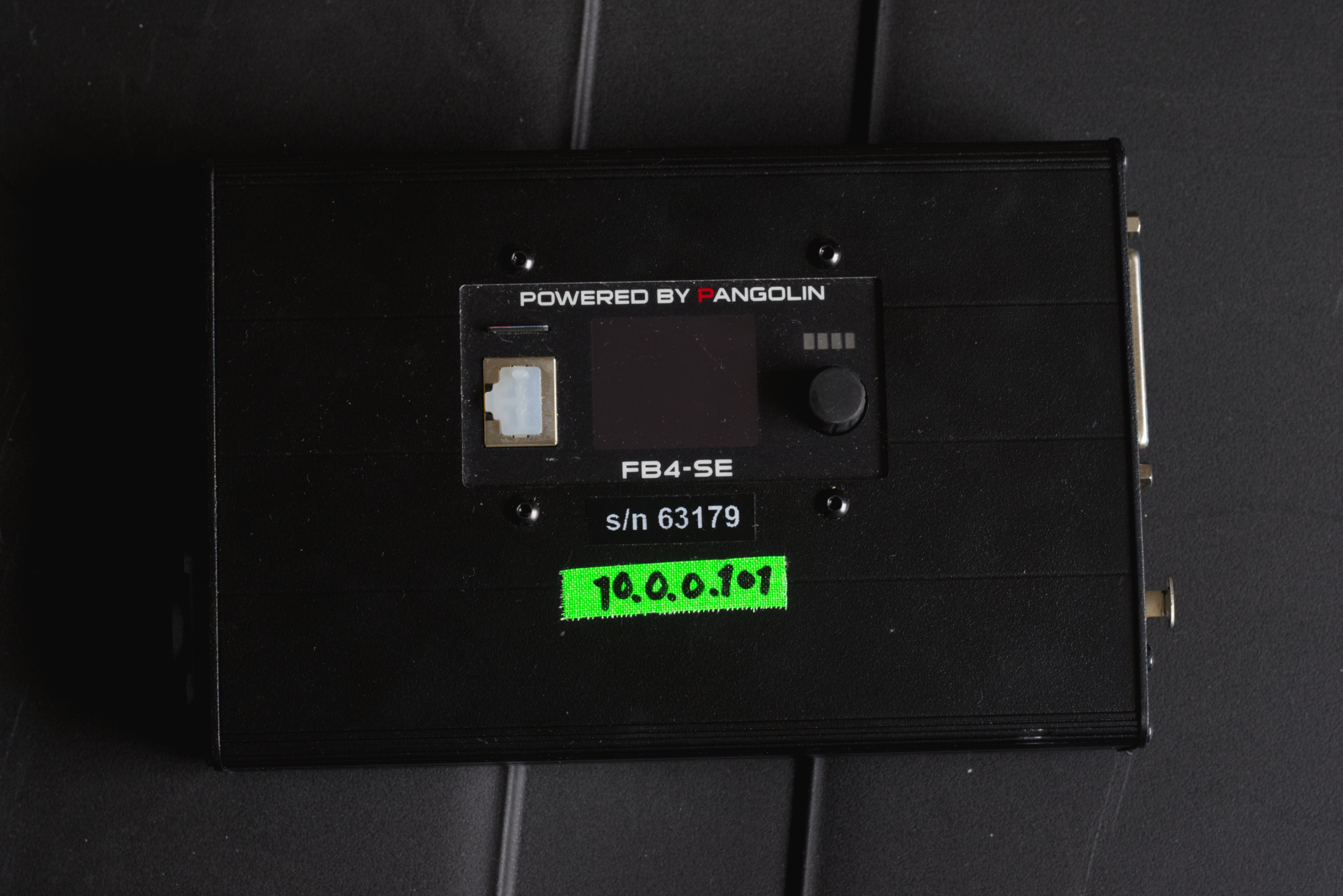 Black electronic device with a small screen, a black knob, a fluorescent green sticker with IP address 10.0.0.101, and a label reading 'Powered by Pangolin' and 'FB4-SE'.
