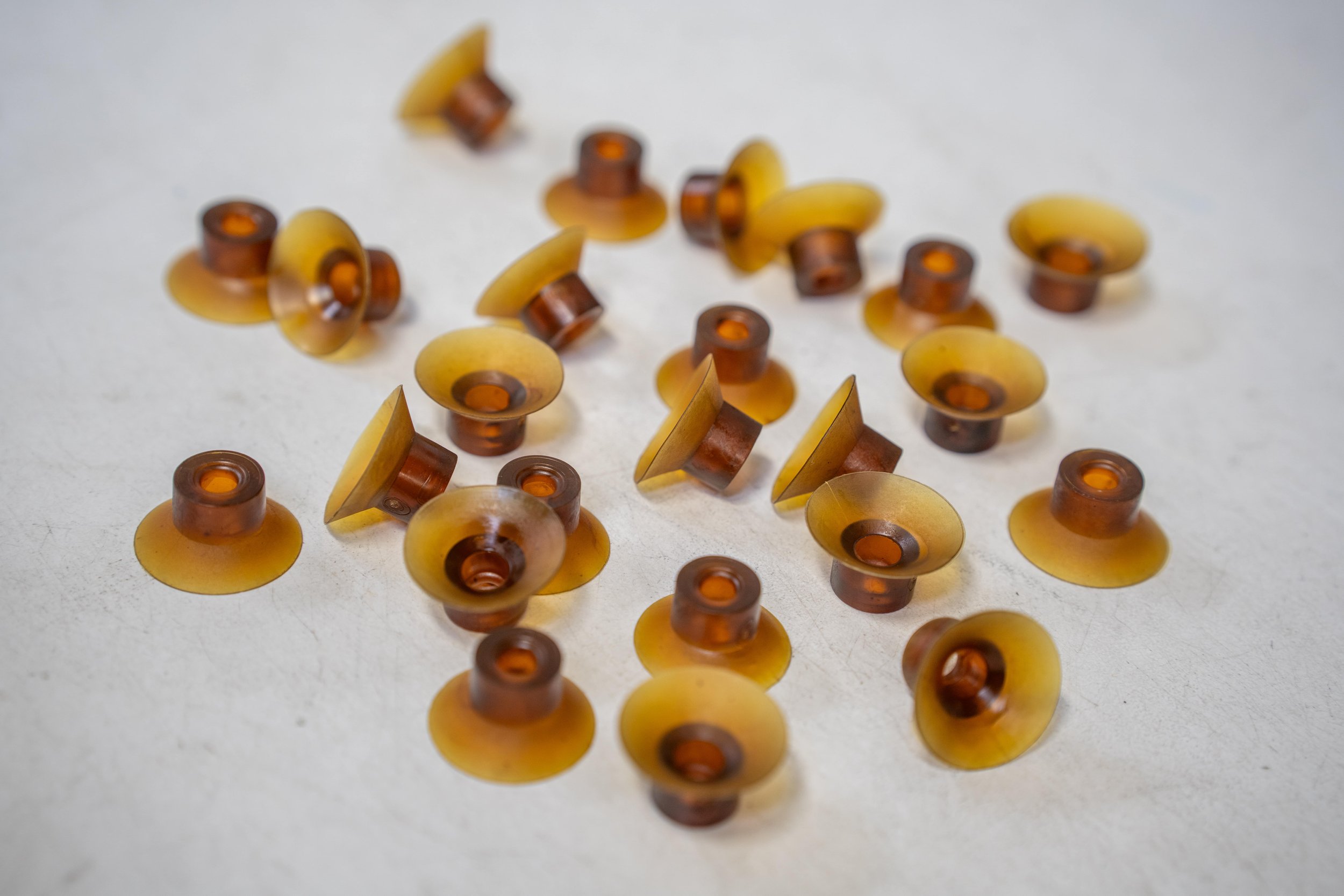 A scattered group of small, round, amber-colored objects with a cylindrical center and a dome-shaped top.