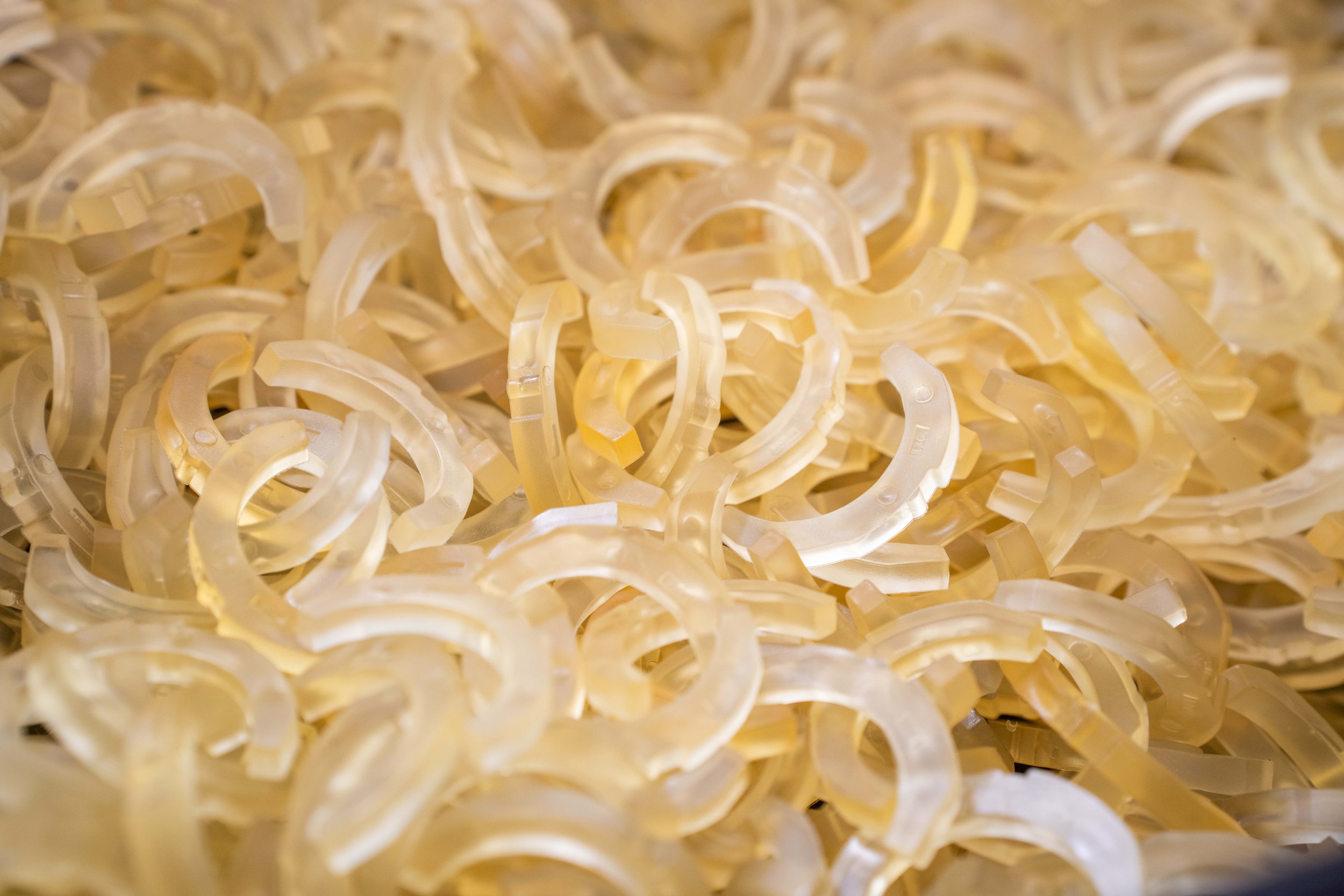 Close-up of numerous small, translucent, curved plastic pieces