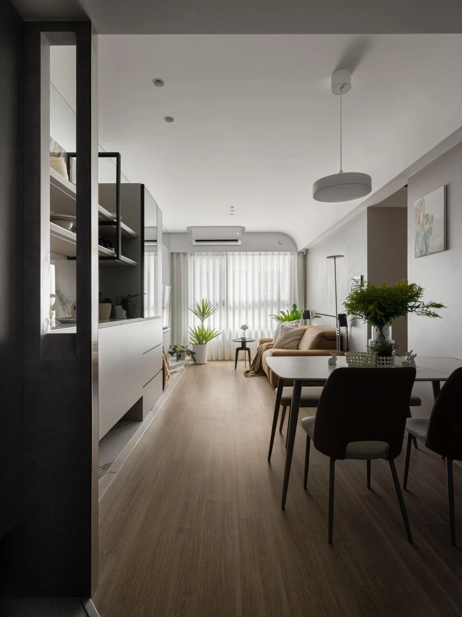 台中南屯13坪小坪數住宅｜泊境隱衡，玄關轉場望向餐廚與客廳，展示收納櫃沿木質地坪形成清楚的生活軸線