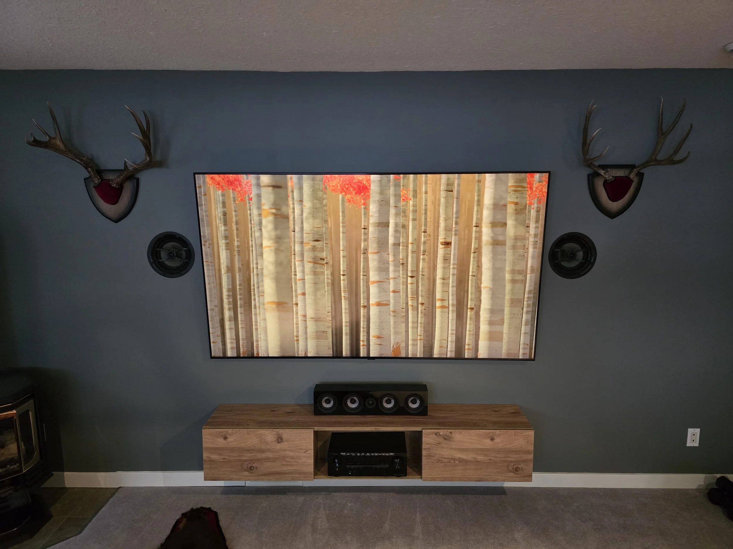 85" TV Wall Mounted with floating TV stand and in-wall speakers.