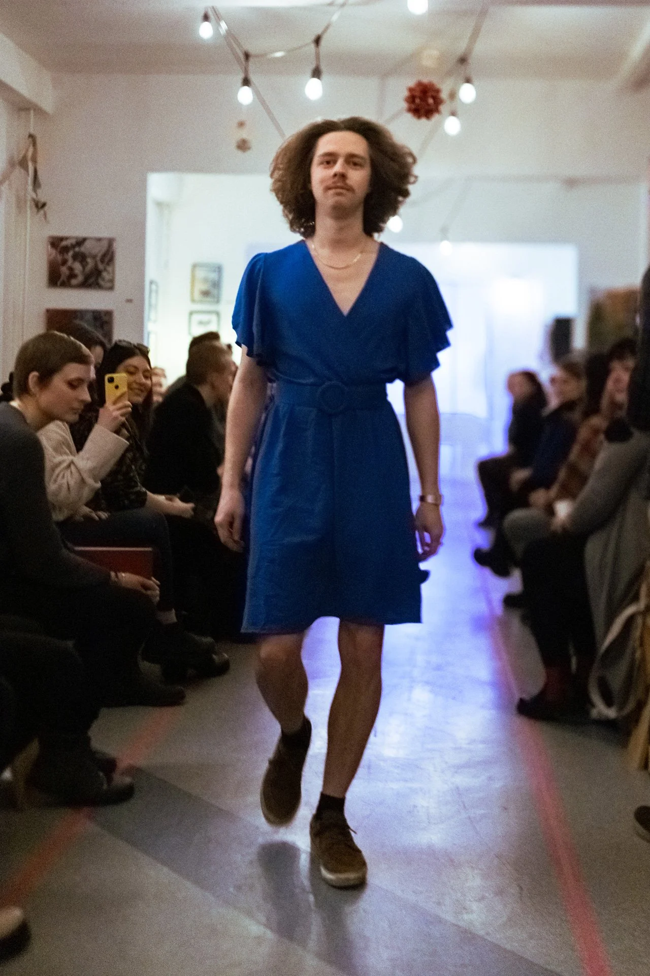 Sara Second Hand in Eisenhüttenstadt, Second Hand & Vintage Mode für alle. Kleidung, Haushaltsartikel & Accessories. Männliches Model auf einem Laufsteg in einem blauen Kleid. Moderne Interpretation der Kleidung für alle.