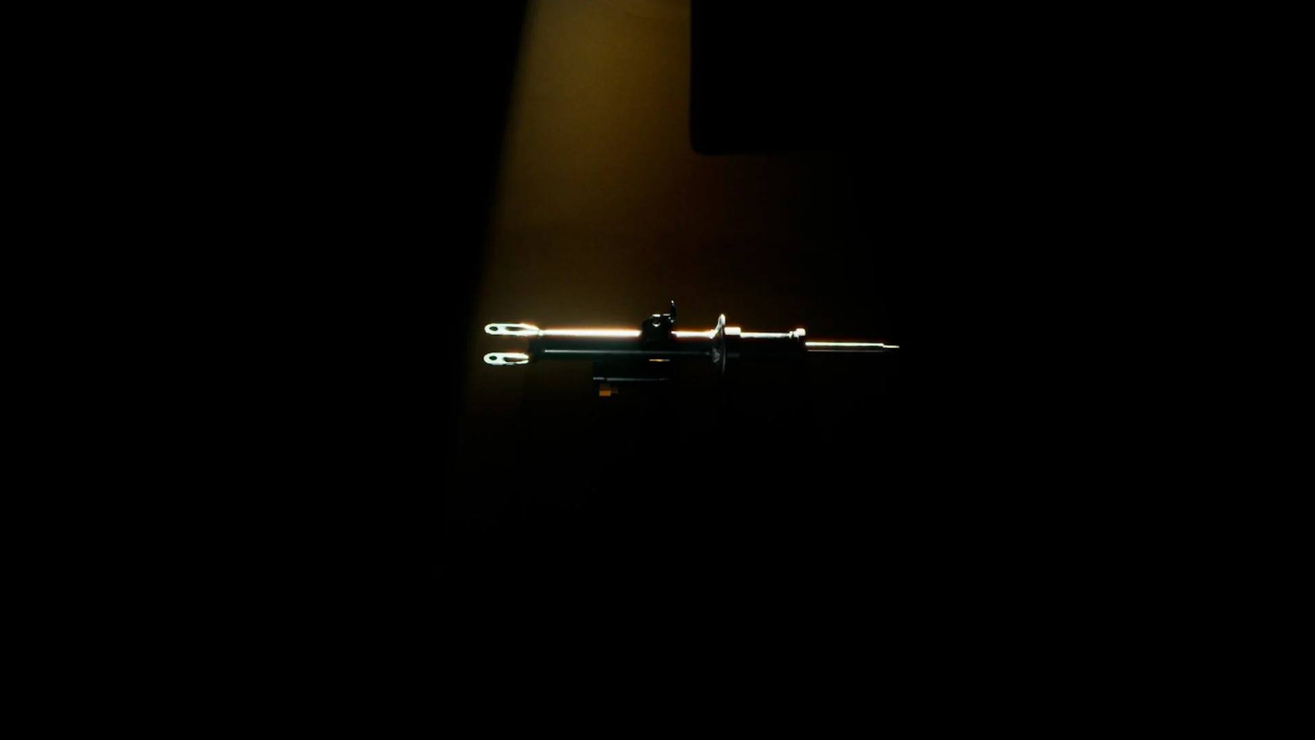 A syringe illuminated with a light in a dark environment.