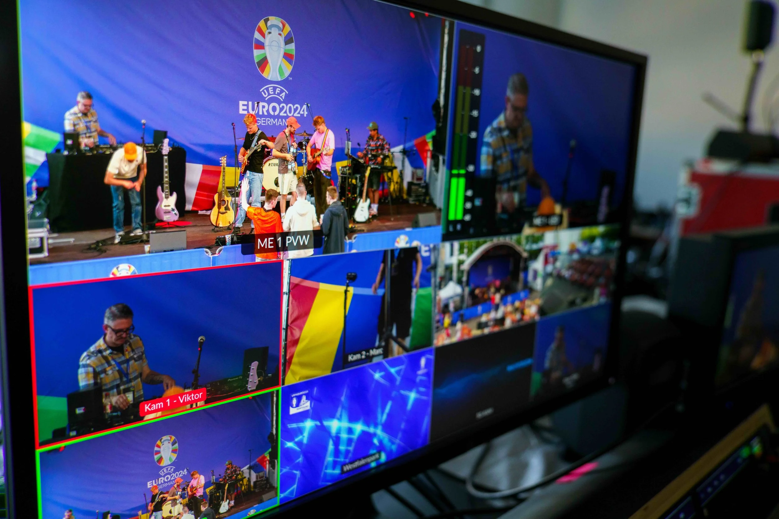 A multi-camera video production monitor displaying a live scene of a music performance at the UEFA Euro 2024 event in Germany, with multiple camera angles and crew members.