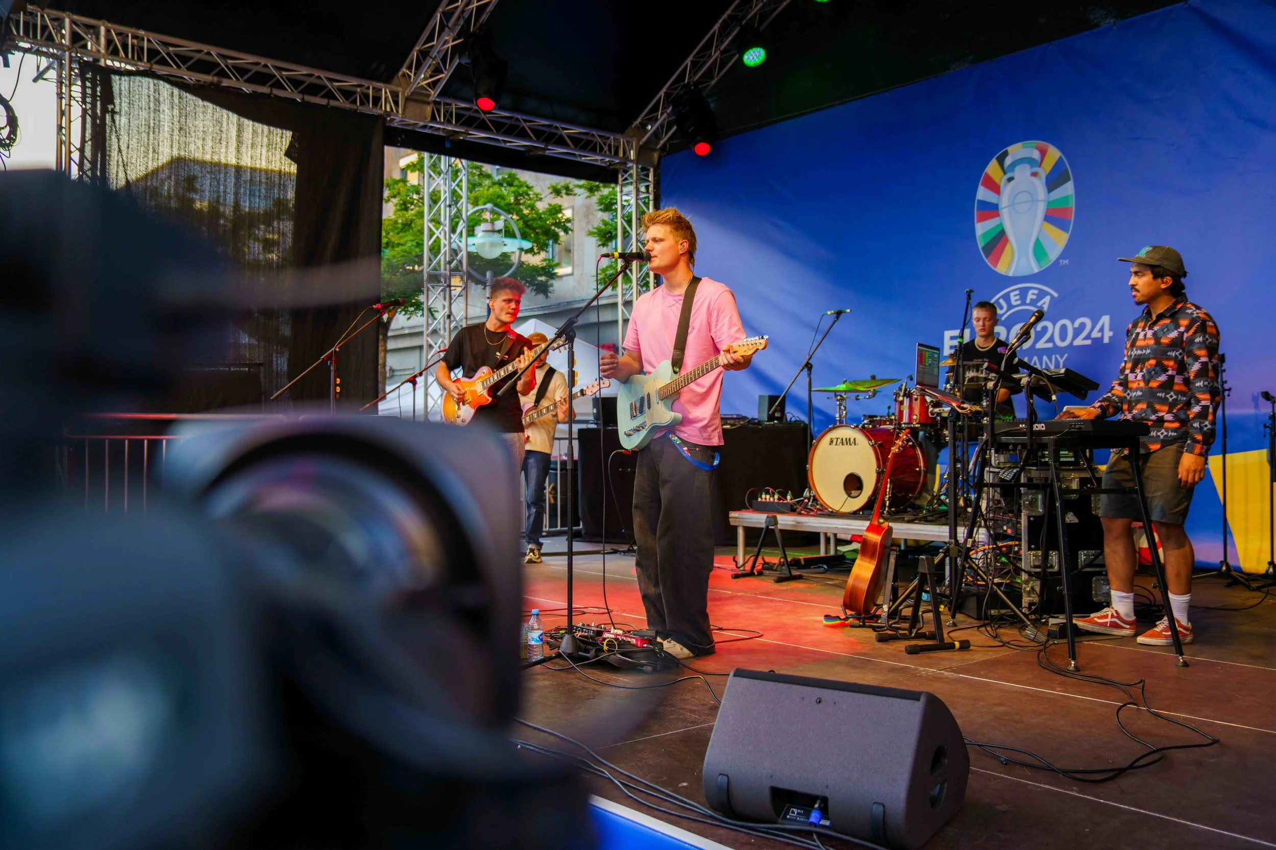 Band performing live on outdoor stage with UEFA Euro 2024 Germany branding behind them.