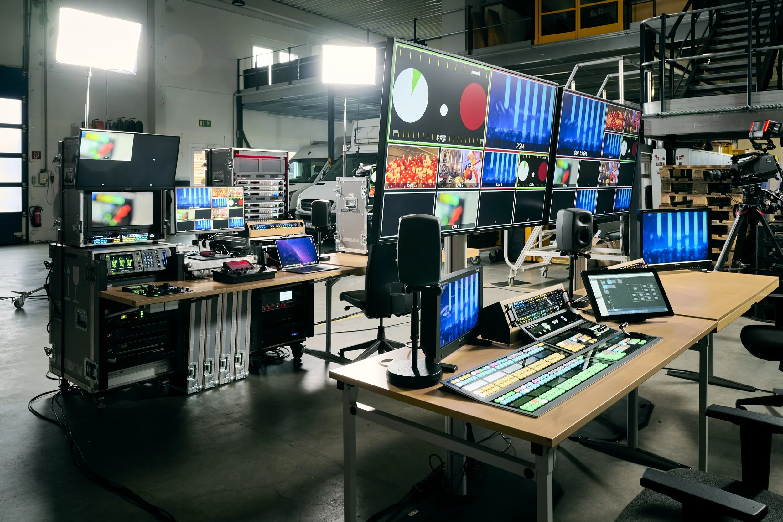 A video production control room with multiple monitors, control panels, and chairs.
