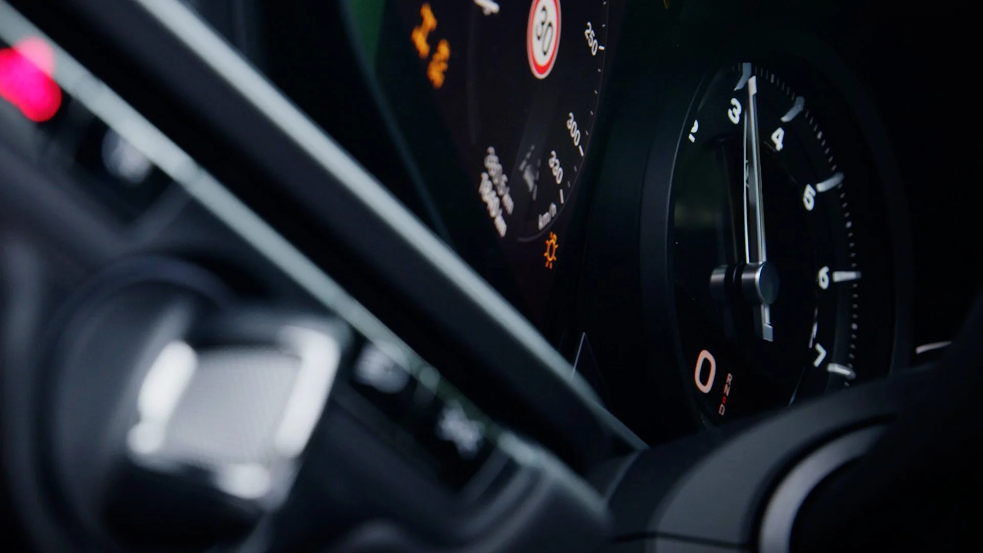 Close-up of a car dashboard showing a digital speedometer, tachometer, and warning lights.