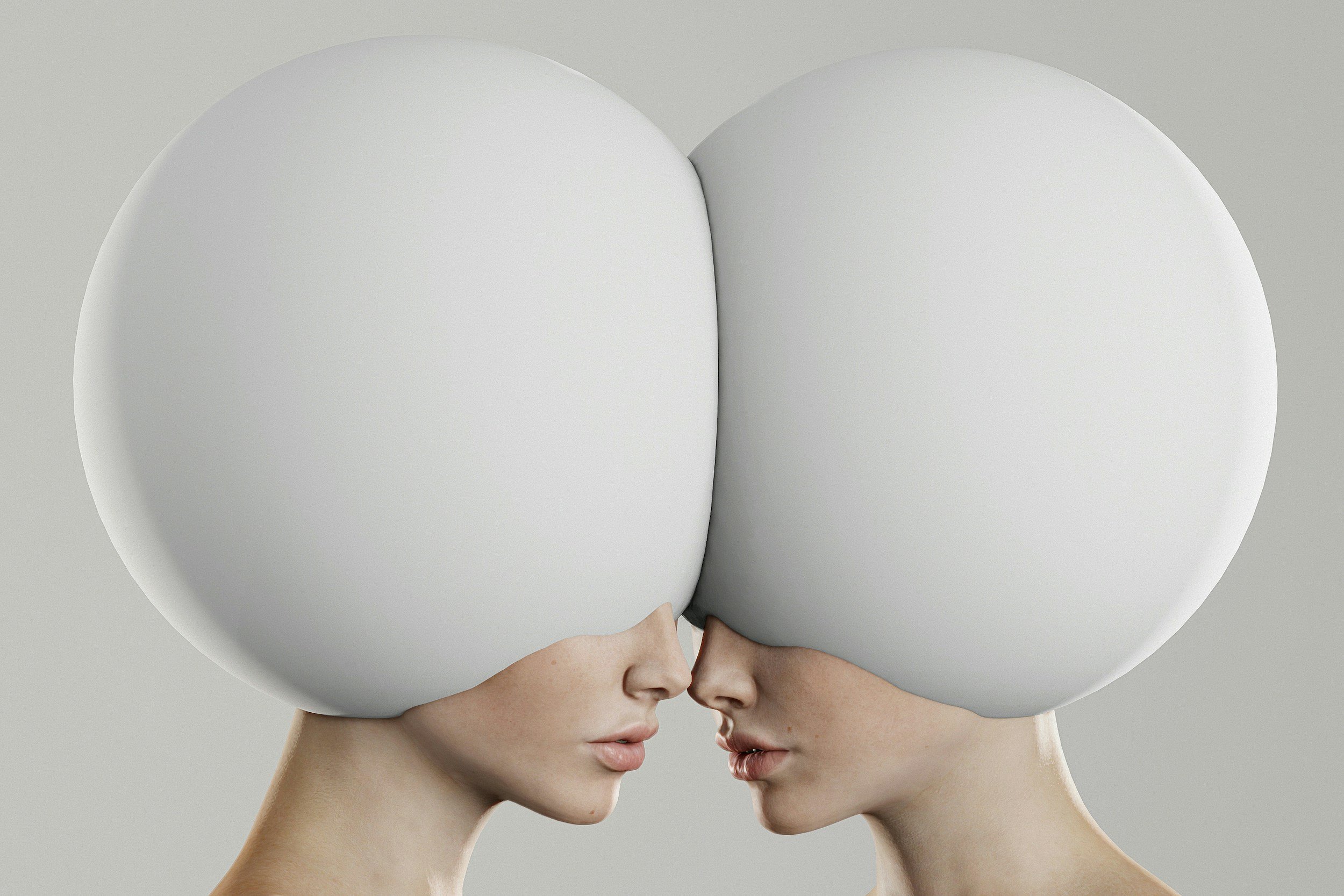Two women with large, spherical white objects covering their heads, touching noses in profile.