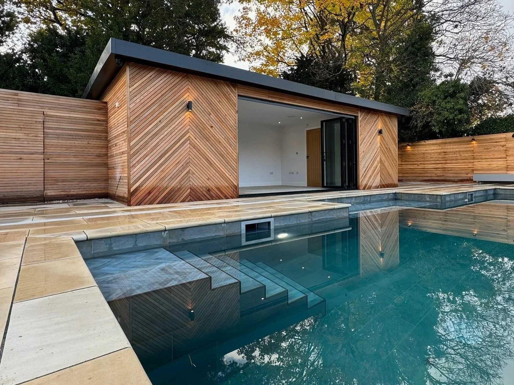 Swimming Pool in millboard composite decking install by Esme Garden Design and Landscaping, a garden design and landscaping company serving surrey, hampshire, berkshire. ascot, london and surrounding areas.