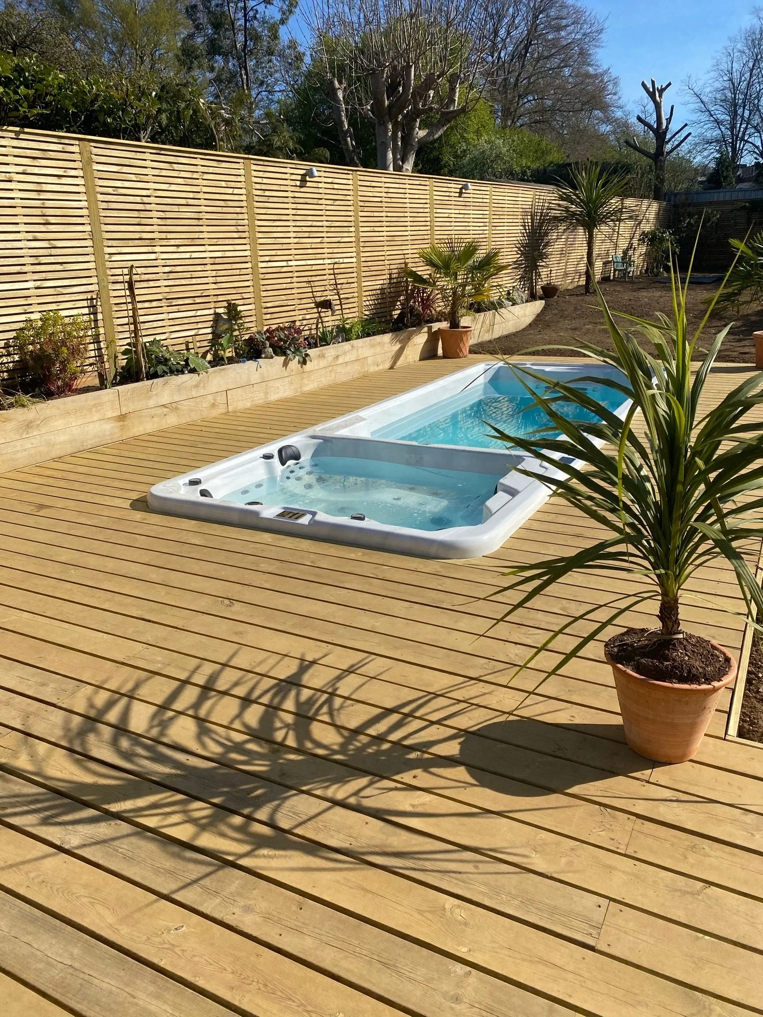 A swim spa in wooden deck. Esme is a garden design & landscaping company serving surrey, hampshire, berkshire, camberley, london & surrounding areas. We build bespoke outdoor living spaces with a hot tub, swim spas, outdoor kitchens, pergola and more