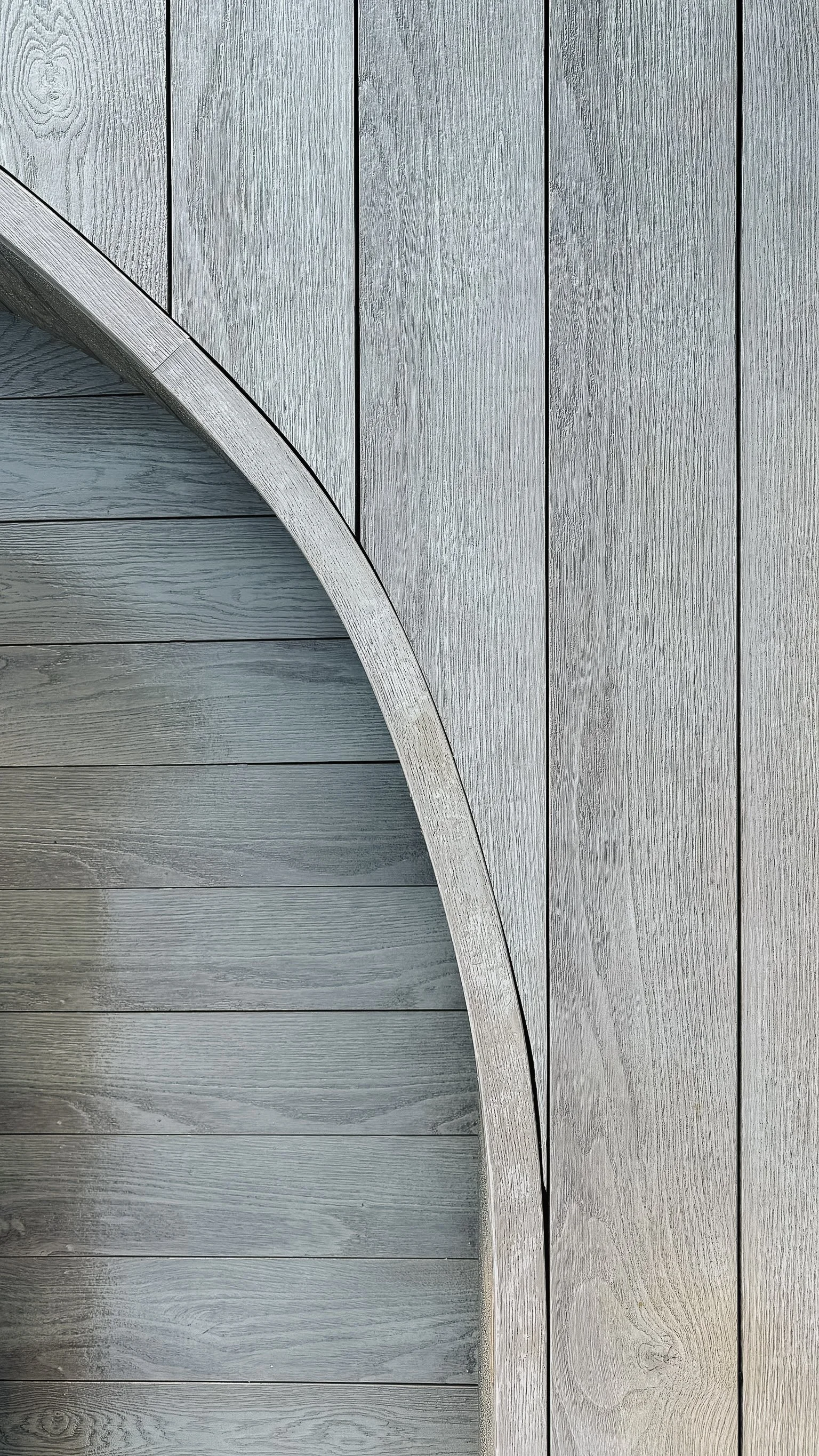 Close-up of a wooden circular structure mounted on a gray wooden wall.