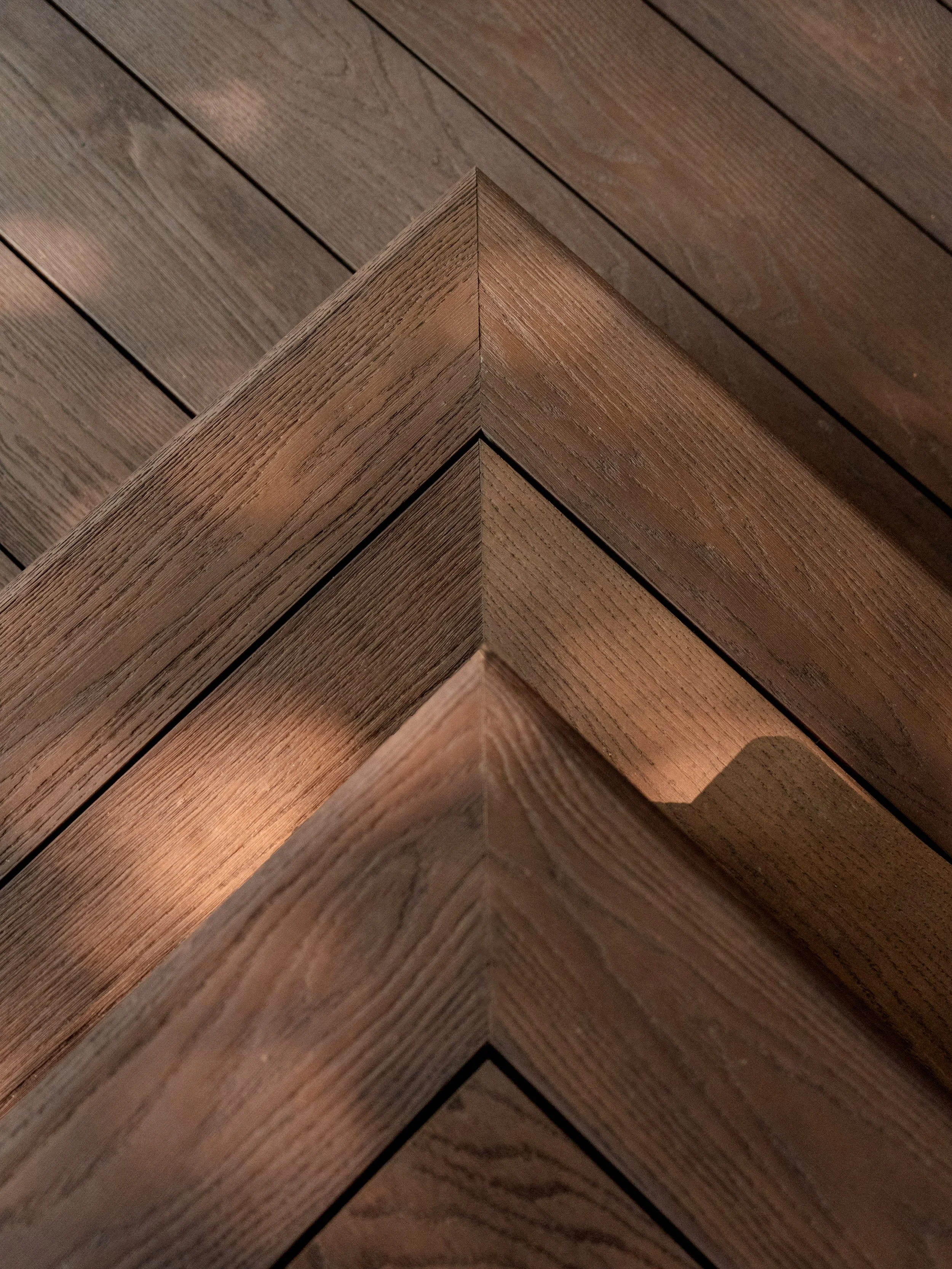 Close-up of "Burnt Cedar" Millboard decking steps. Expert landscapers and garden designers in Surrey, Hampshire, Berkshire, Camberley, London and surrounding areas.