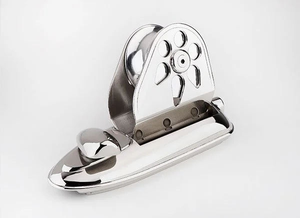 A stainless steel nail clipper with a built-in nail file, placed on a white surface.