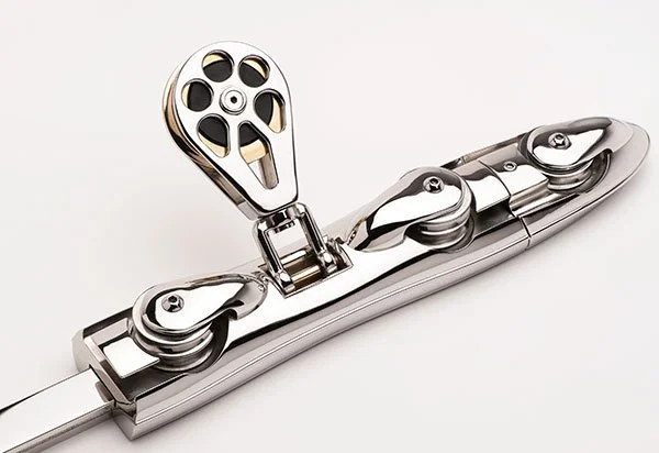 A close-up of a shiny metal window lock with a movable latch and rotating mechanism.