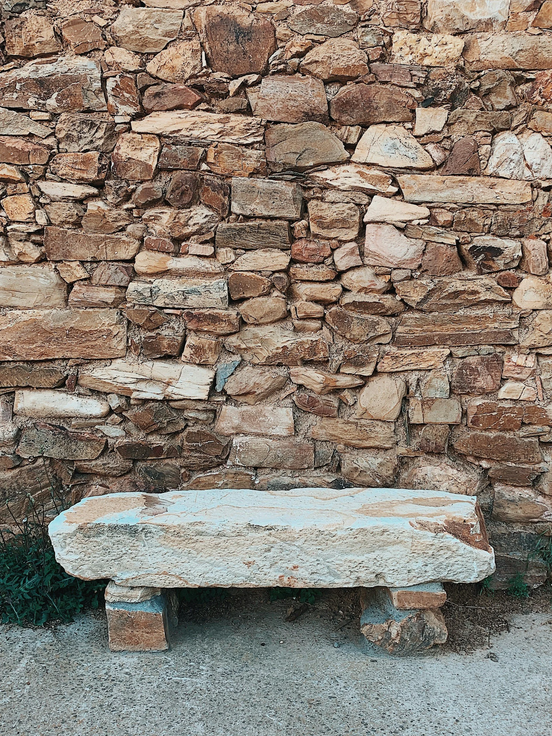 Steinbank vor einer Steinmauer