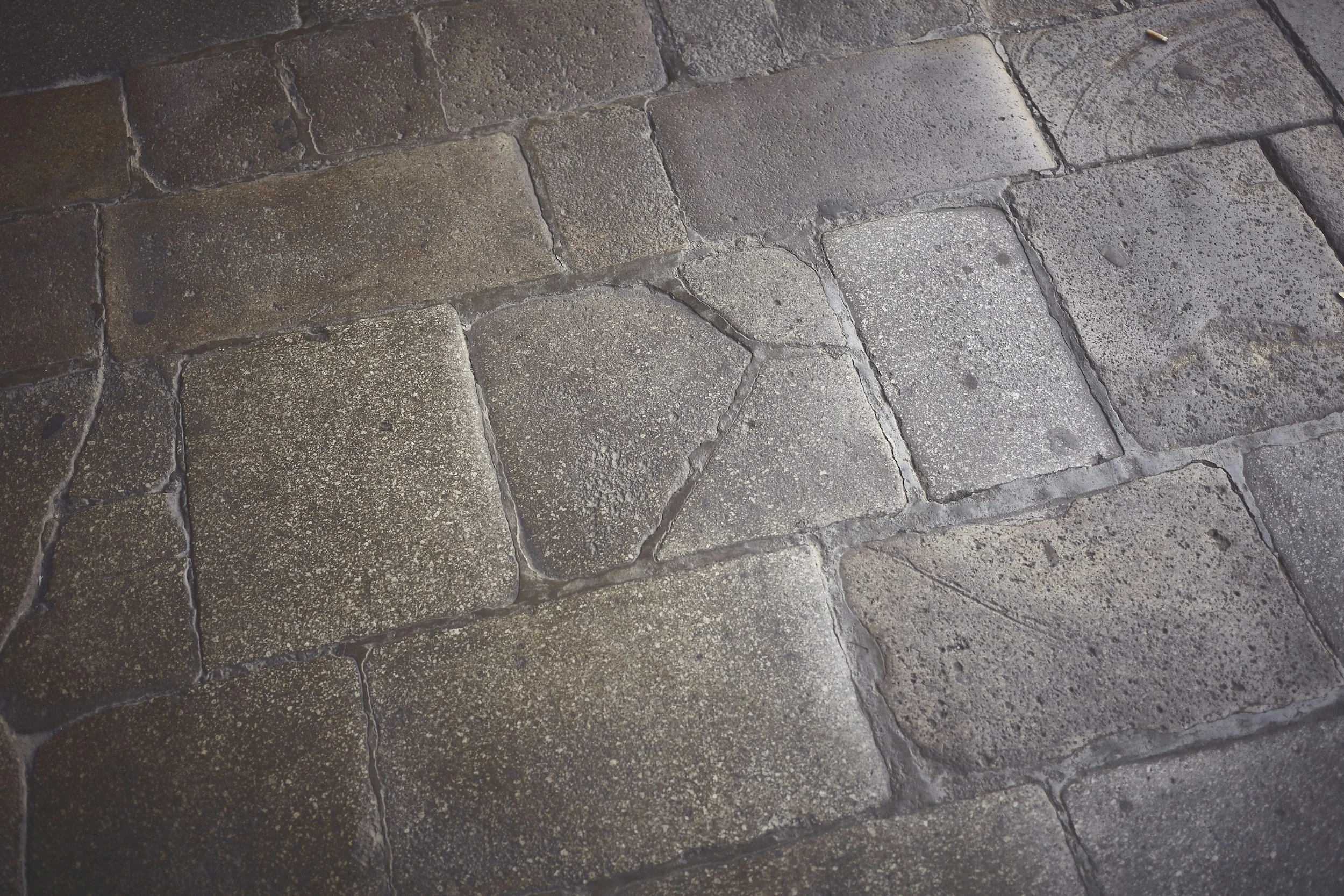 Bodenfurchen aus alten Steinplatten mit Mörtelzwischenräumen.