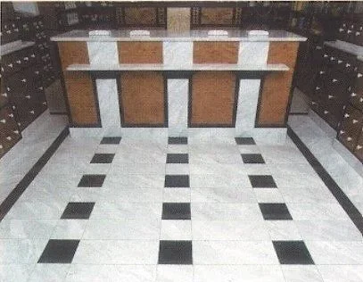 Ein Innenraum mit schwarzen und weißen Fliesen und einem Empfangstresen aus Holz.