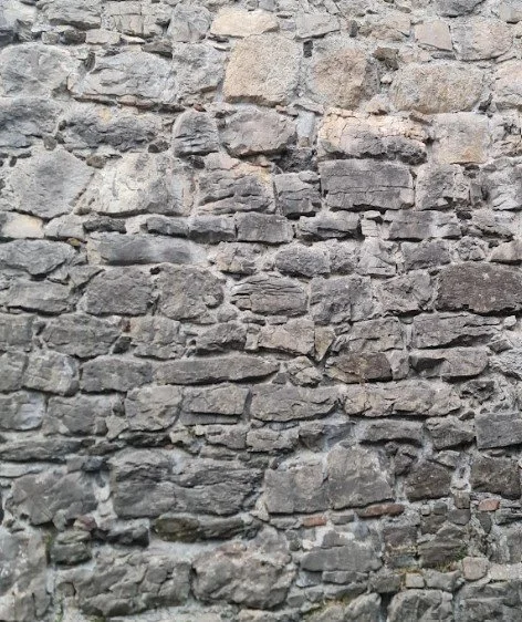 Eine alte Steinmauer aus unregelmäßig geformten Steinen