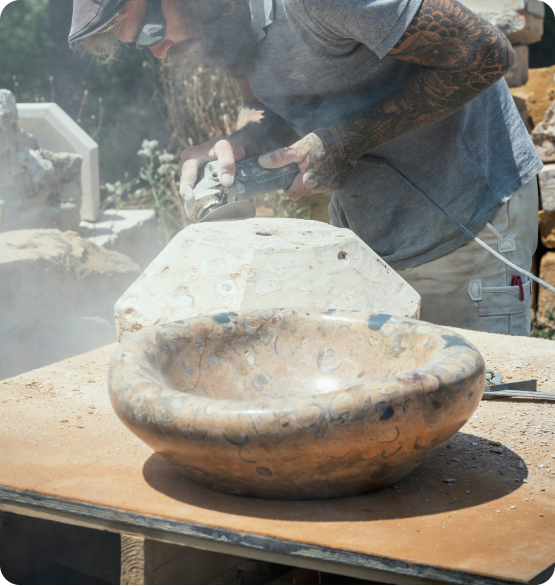 Mann schleift Steine bei der Steinmetzkunst, öffnet eine Staubwolke.