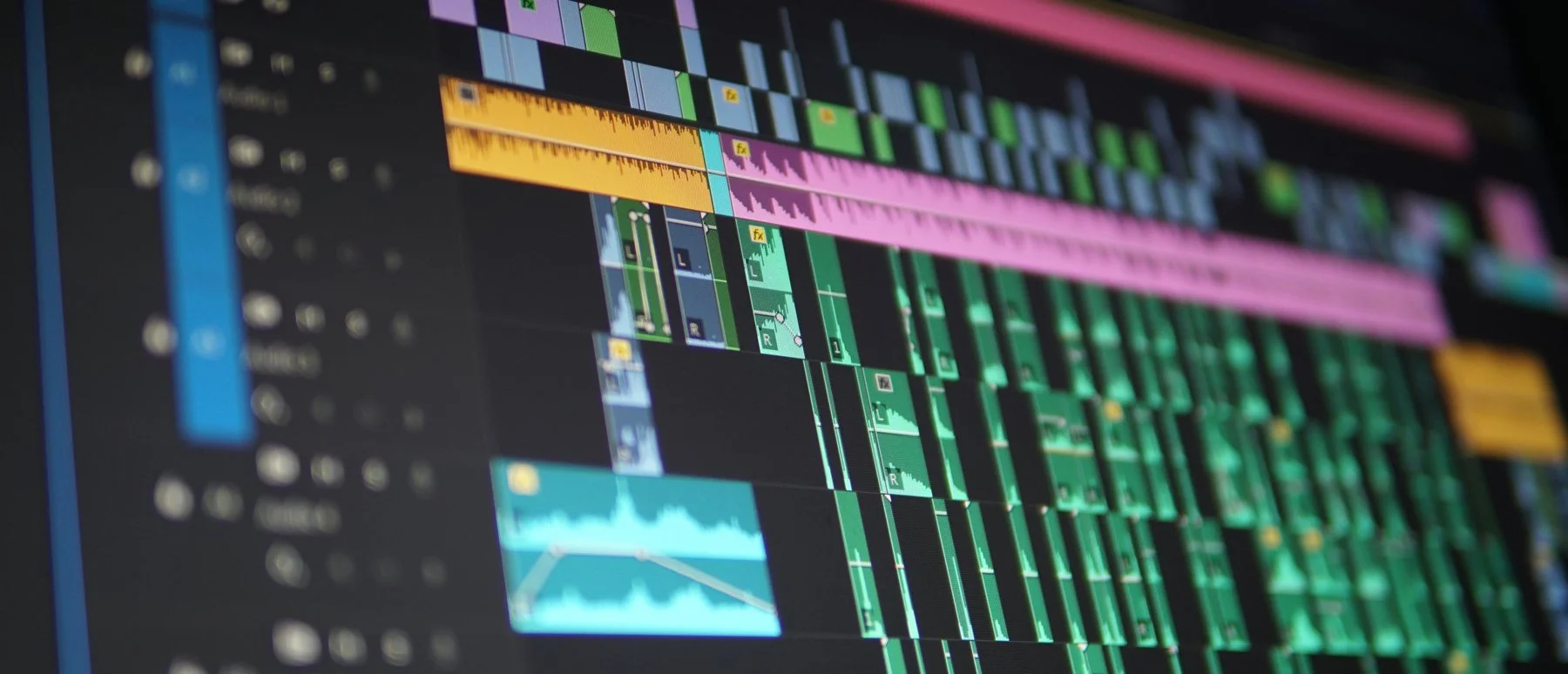 A digital audio workstation screen displaying multiple colorful tracks, waveforms, and audio editing controls.