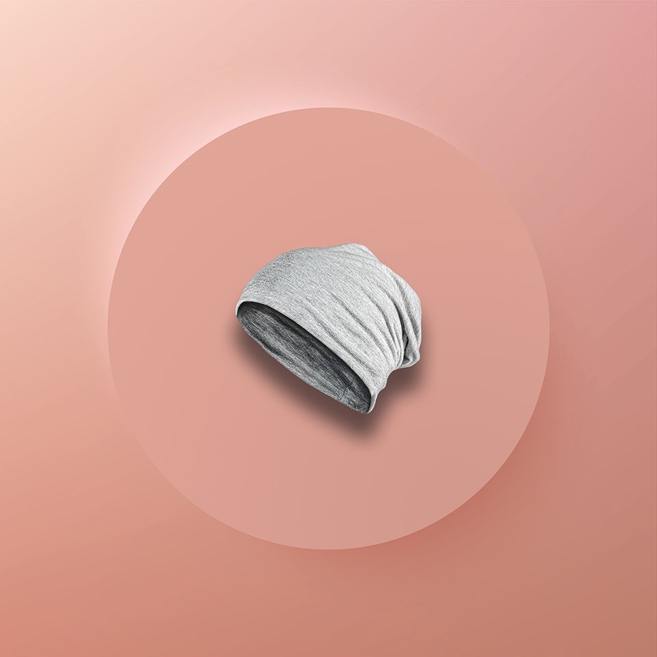 Gray beanie hat on a pink background with a circular pink shadow.