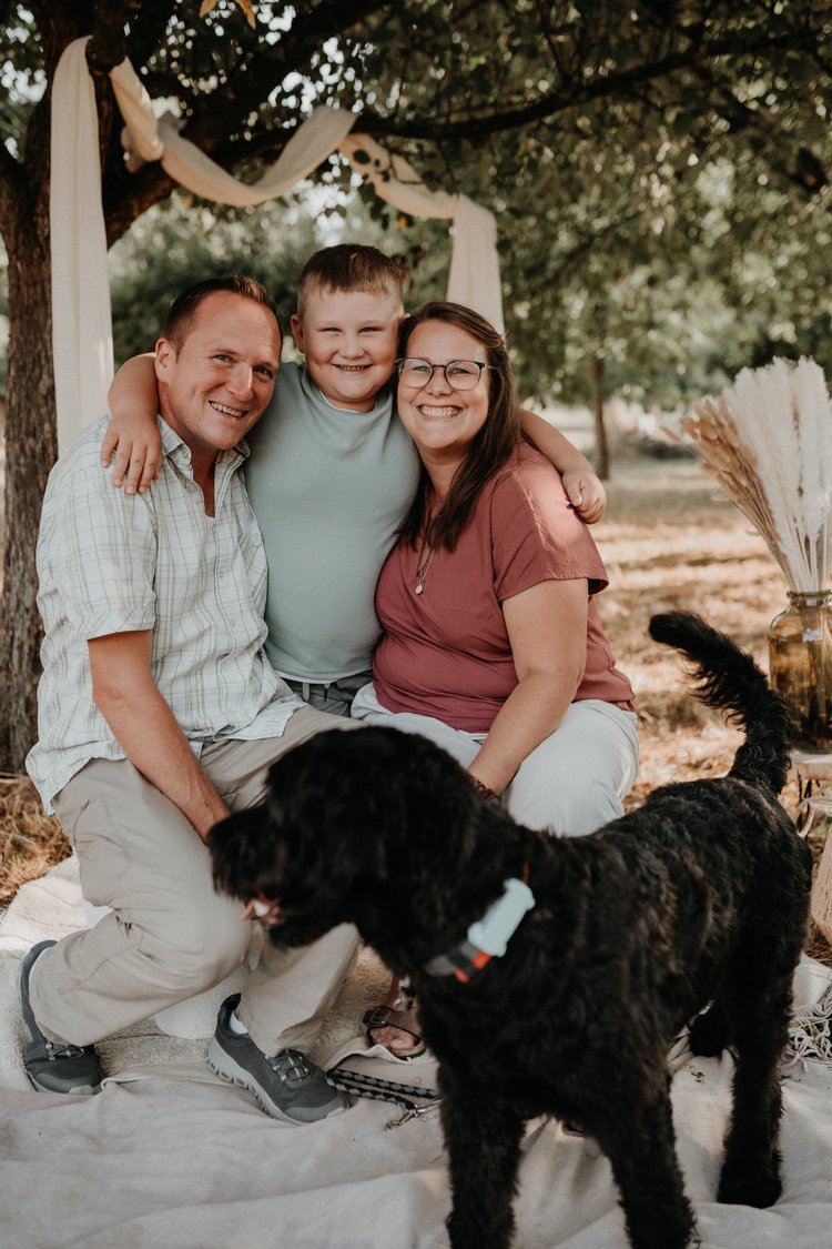 Familie mit Hund vor der hellen Stoffkulisse beim Minishooting