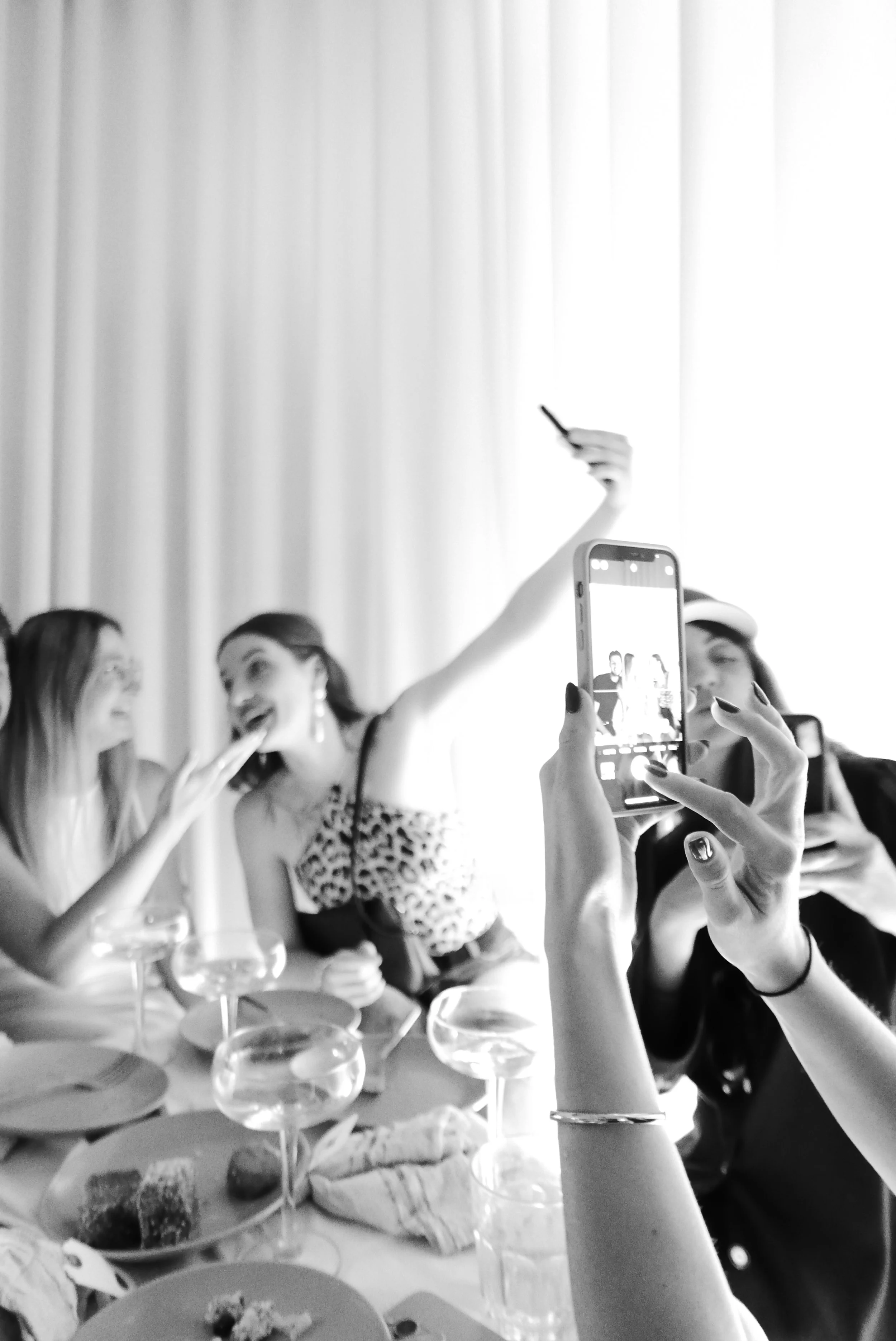 People taking photos and celebrating at a party with food and drinks on the table.