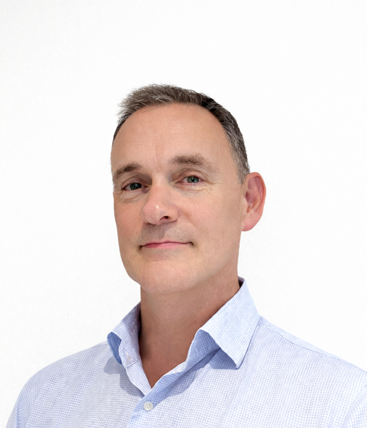Close-up headshot of a middle-aged man with short dark hair, wearing a light blue collared shirt, against a plain white background.
