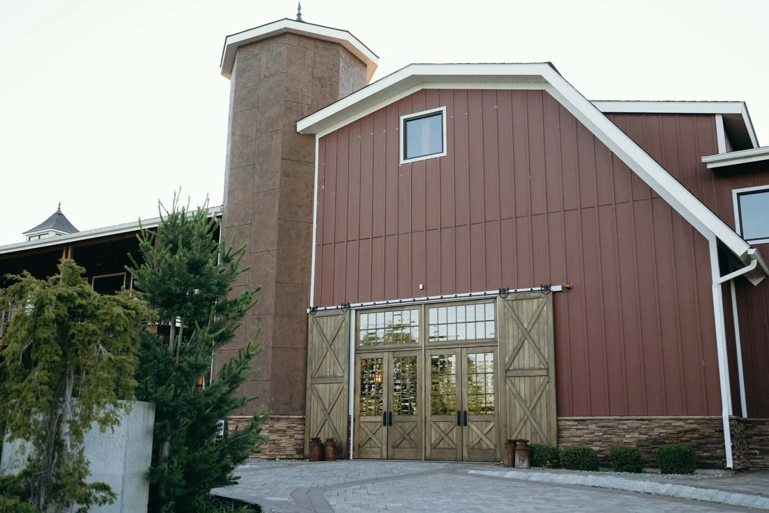 Exterior view of The Barn at Villa Venezia featuring rustic red siding and wooden barn entrance doors