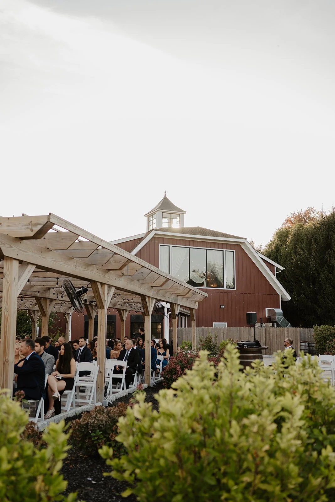 Image of The Barn's outdoor ceremony space featuring a pergola and landscaping just steps away from the doors.