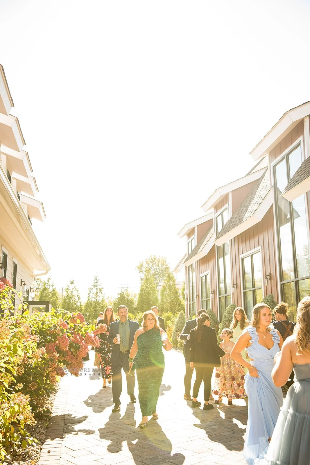 Guests dressed in colorful summer attire socializing outdoors on a beautiful sunny day at a Hudson Valley wedding