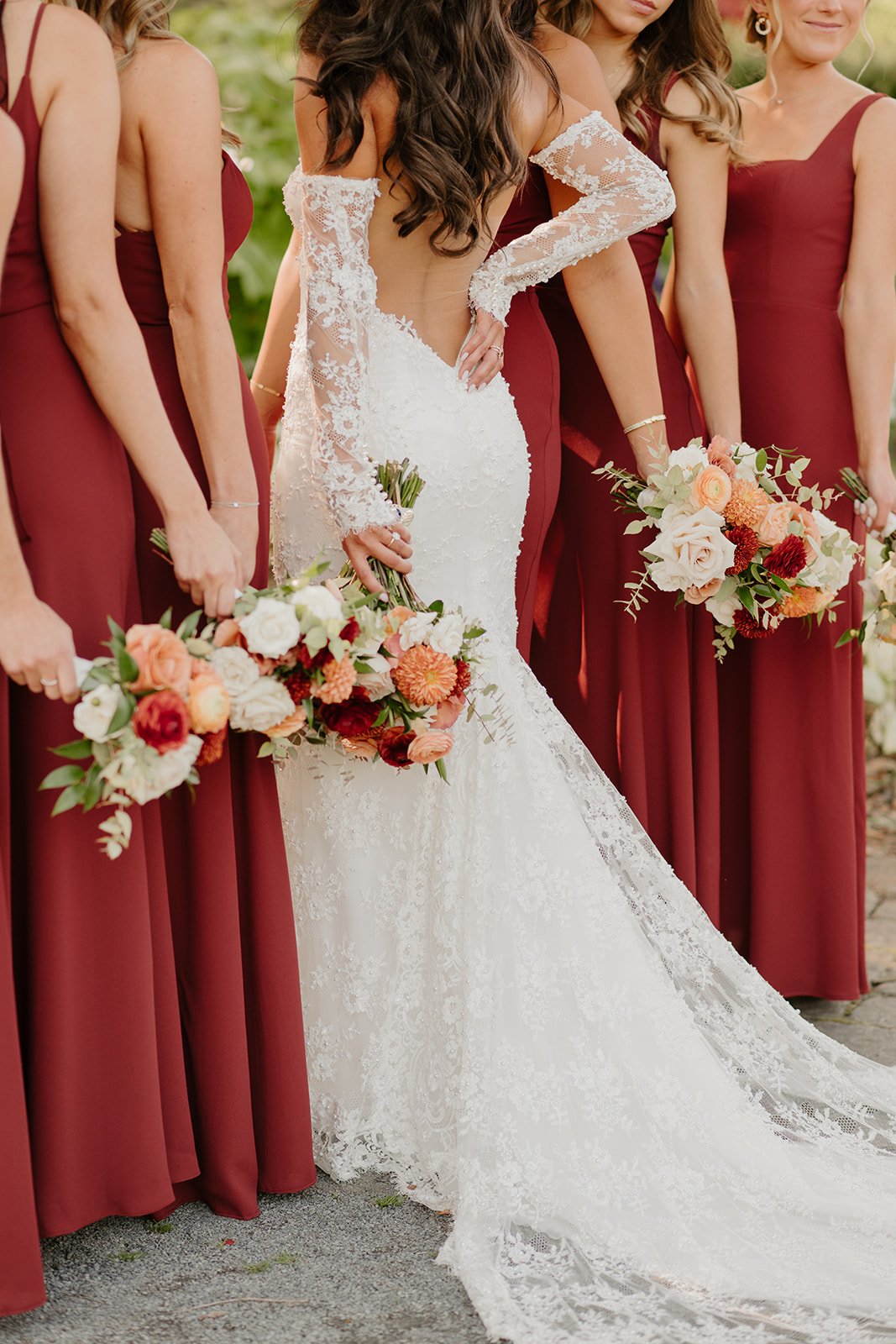 A bride poses for a photo with her bridesmaids dressed in colors inspired by the Hudson Valley