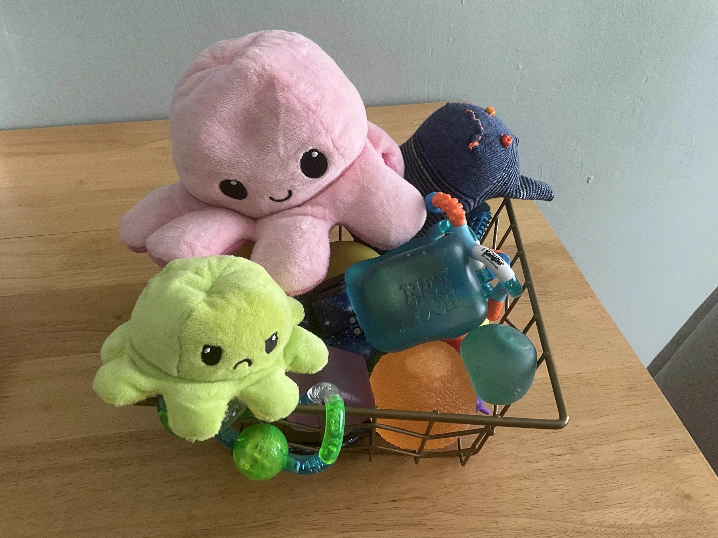 Variety of fidgets in previous image in a gold wire bowl
