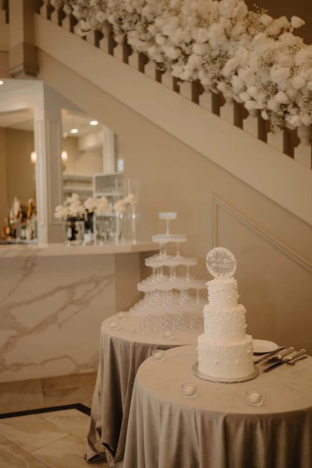 A three-tiered wedding cake with all white decorations