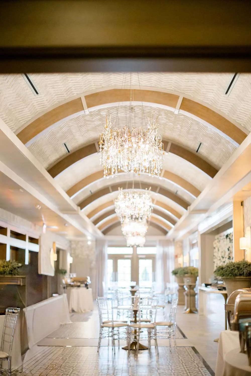 Indoor pre-function gallery with grand barrel-vaulted ceilings and crystal chandeliers at a luxury wedding venue in the Hudson Valley.