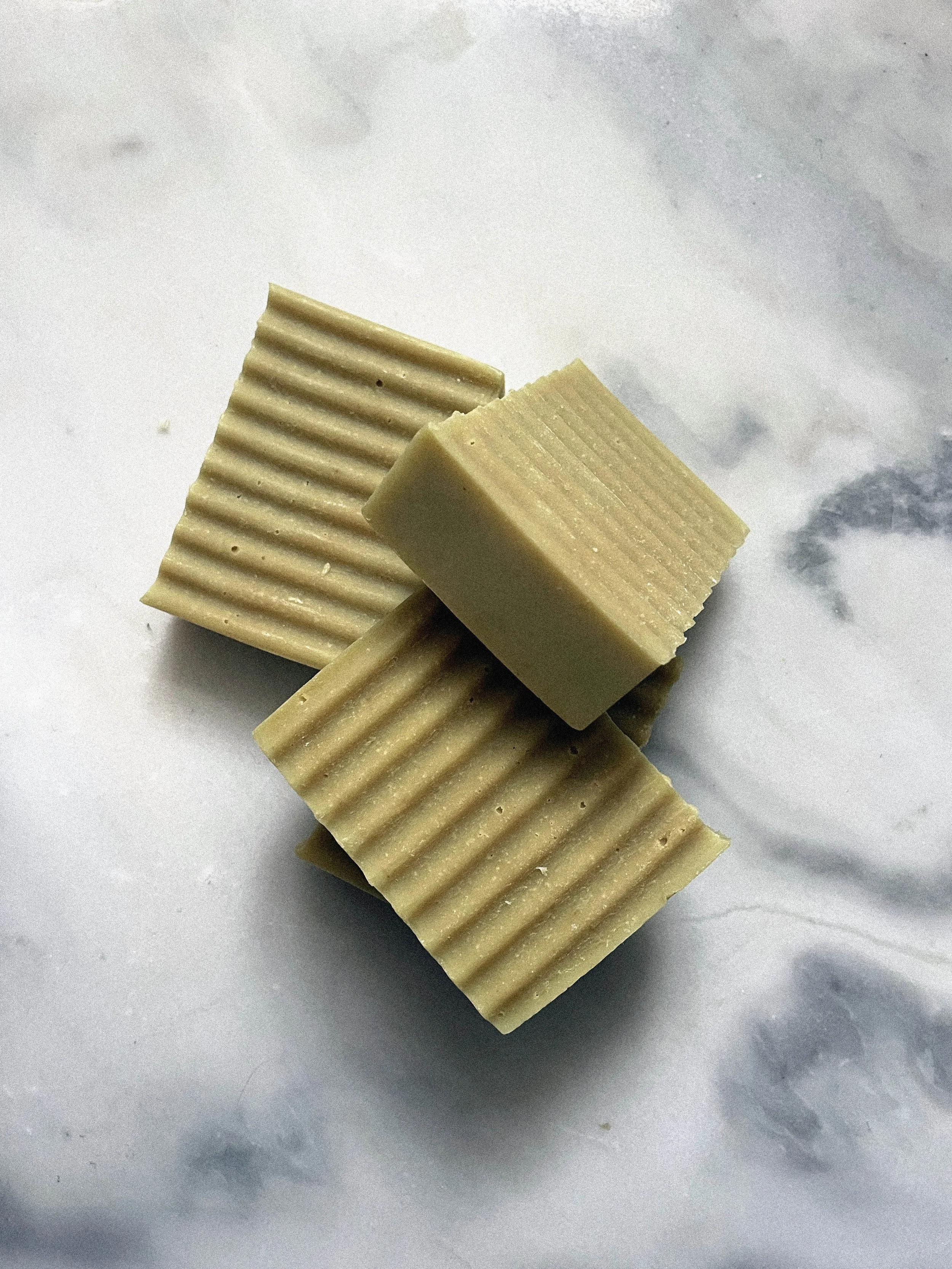 Drei weiße Schokoladentafeln mit gerillten Oberflächen auf einem weißen Marmor-Hintergrund.