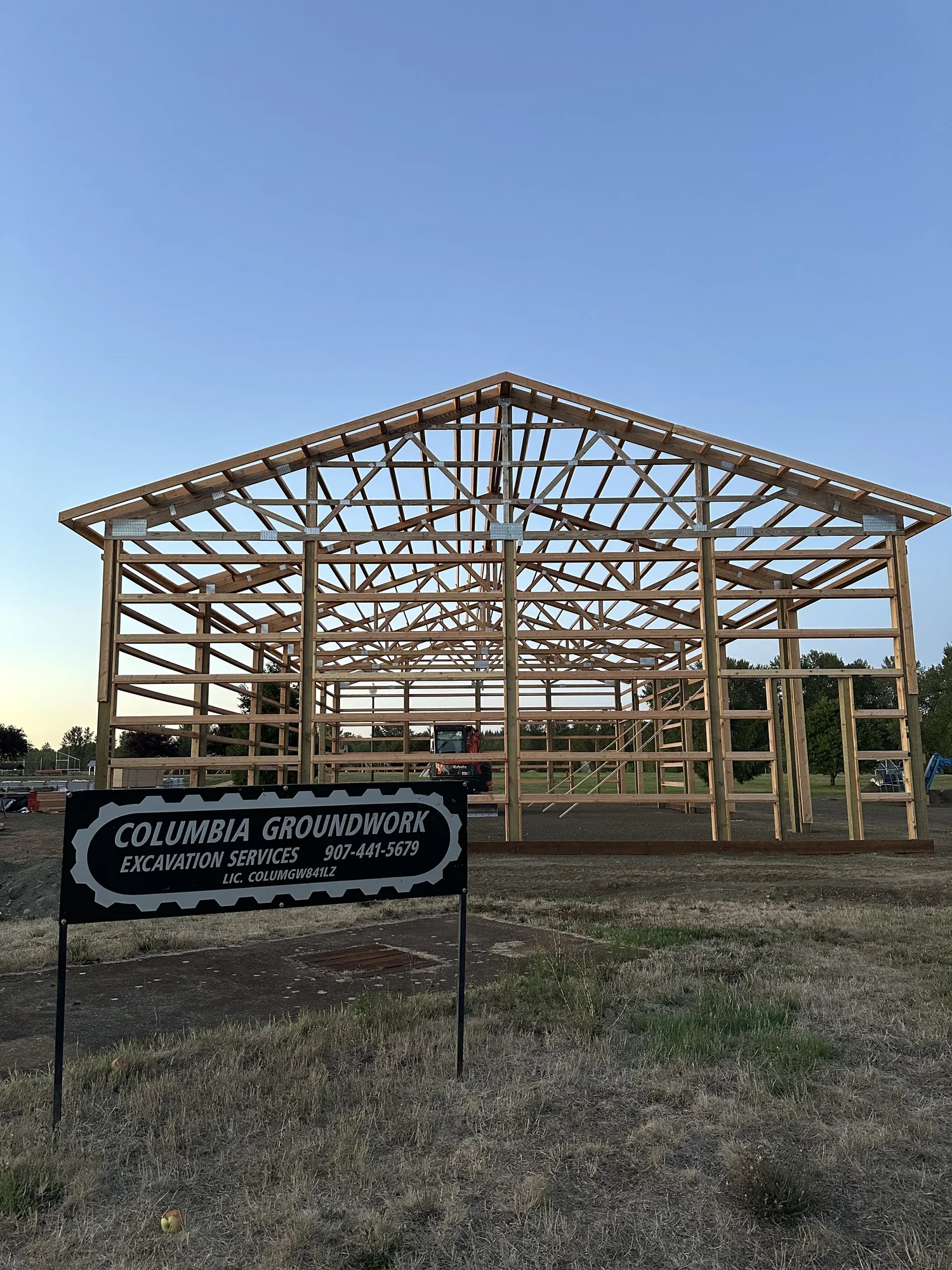 Roof trusses being installed on a post-frame building