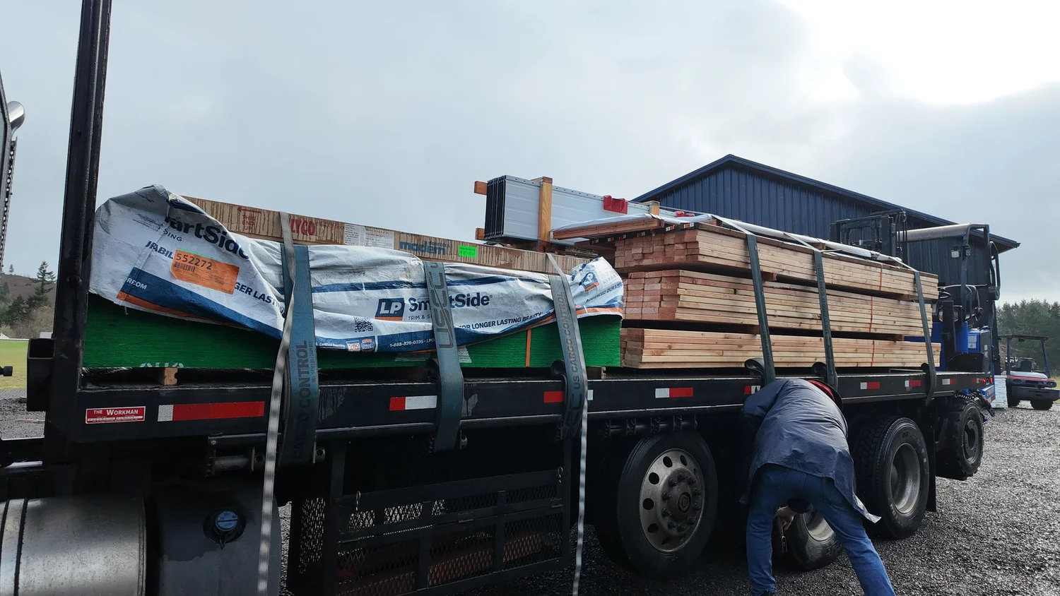 Flatbed truck loaded with lumber for pole barn kit delivery