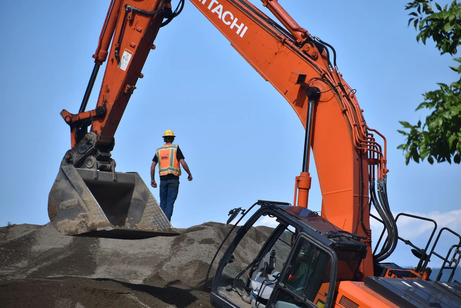 Excavator preparing a level building pad before construction