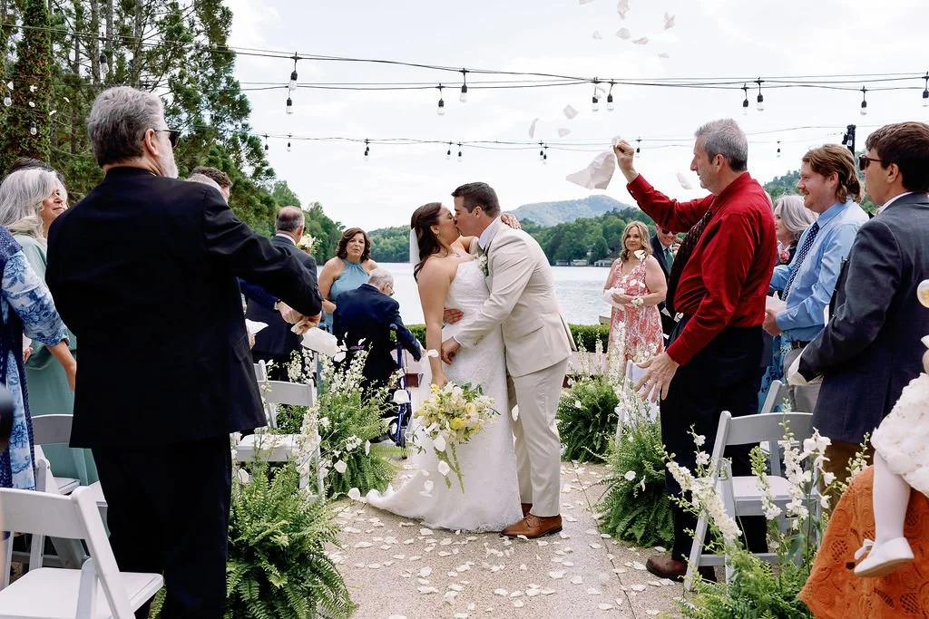 lakeside wedding with white floral aisle arrangements.