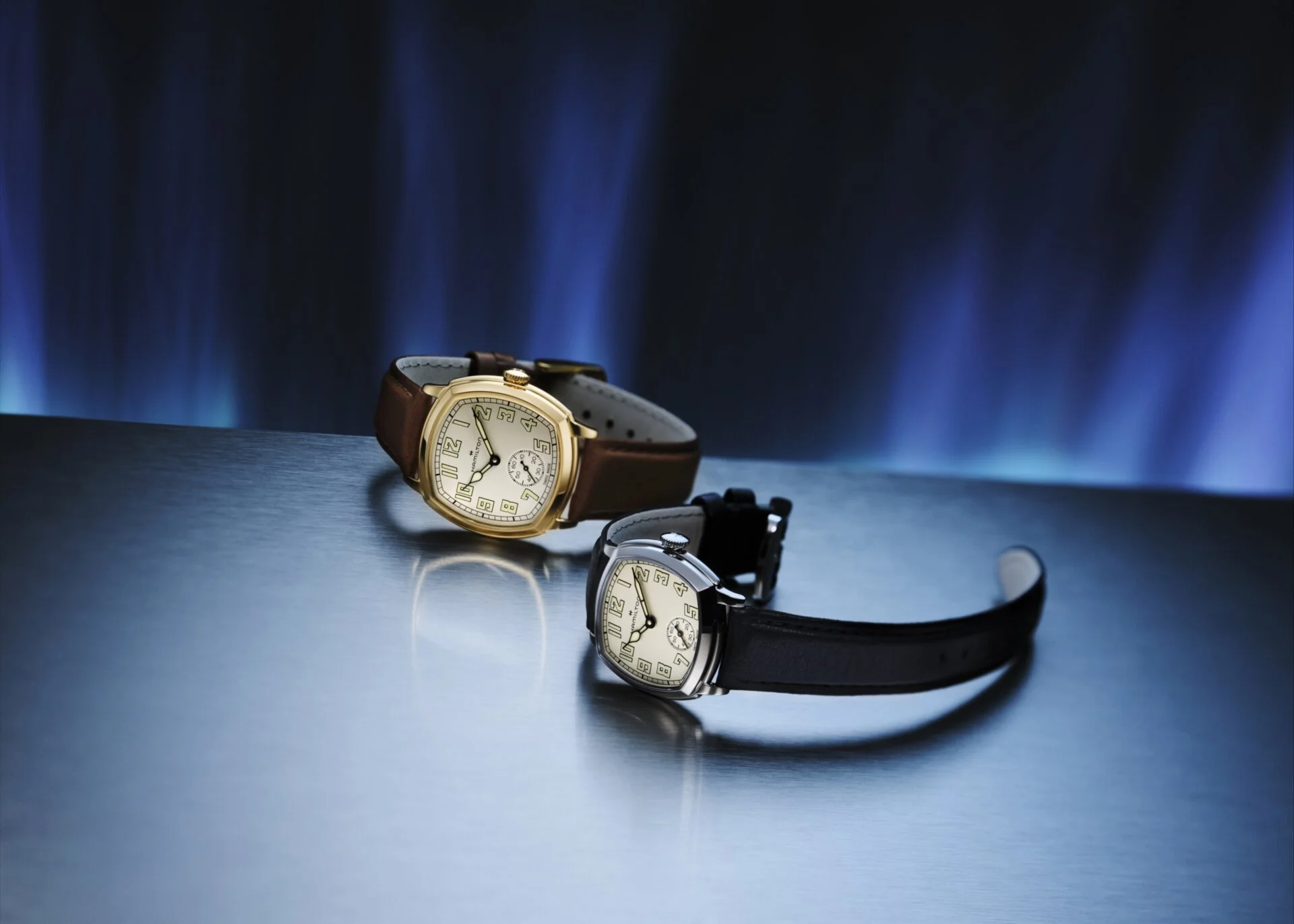 Two Hamilton cushion case watches next to each other, one in stainless steel and one in PVD gold