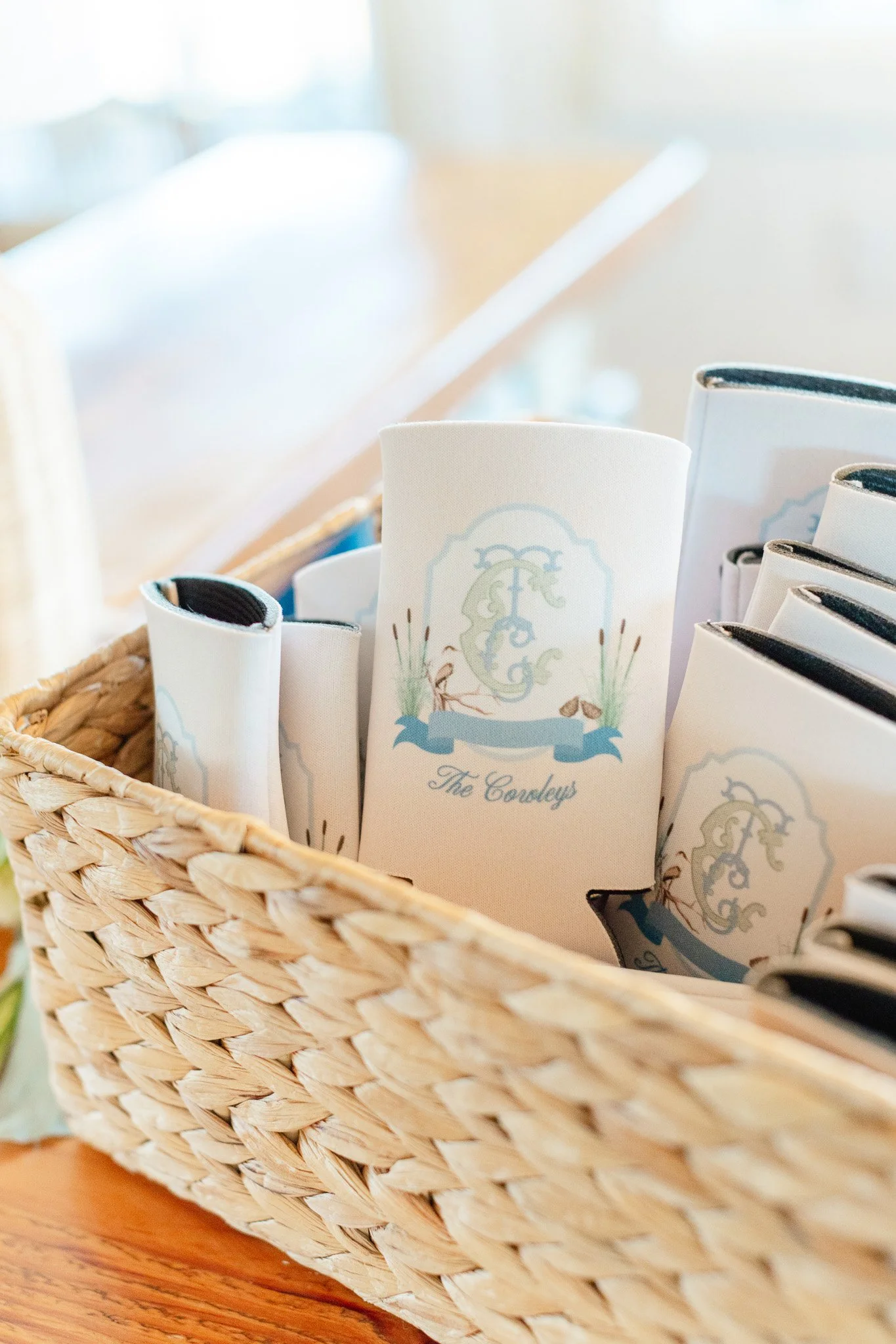 Basket containing personalized napkins with a monogram and the text 'The Coudys' for a wedding or special event.