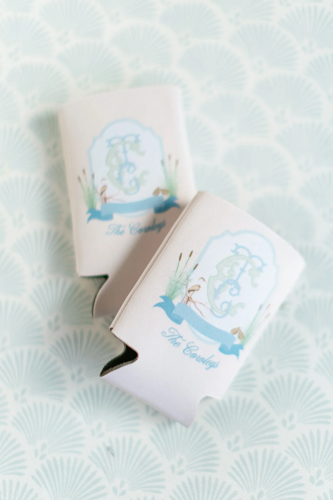 Two white cardholders with a blue and green logo and text 'The Counley' on a light blue patterned background.