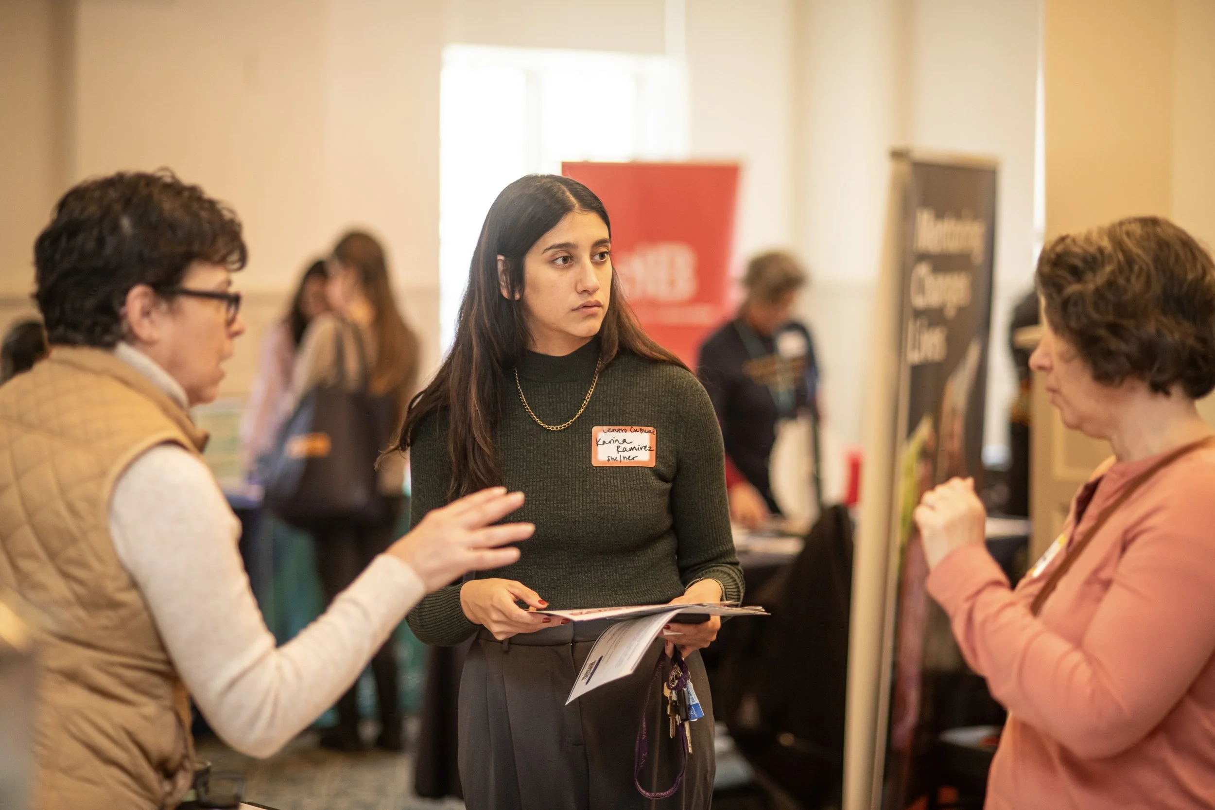 Three women talking at networking event