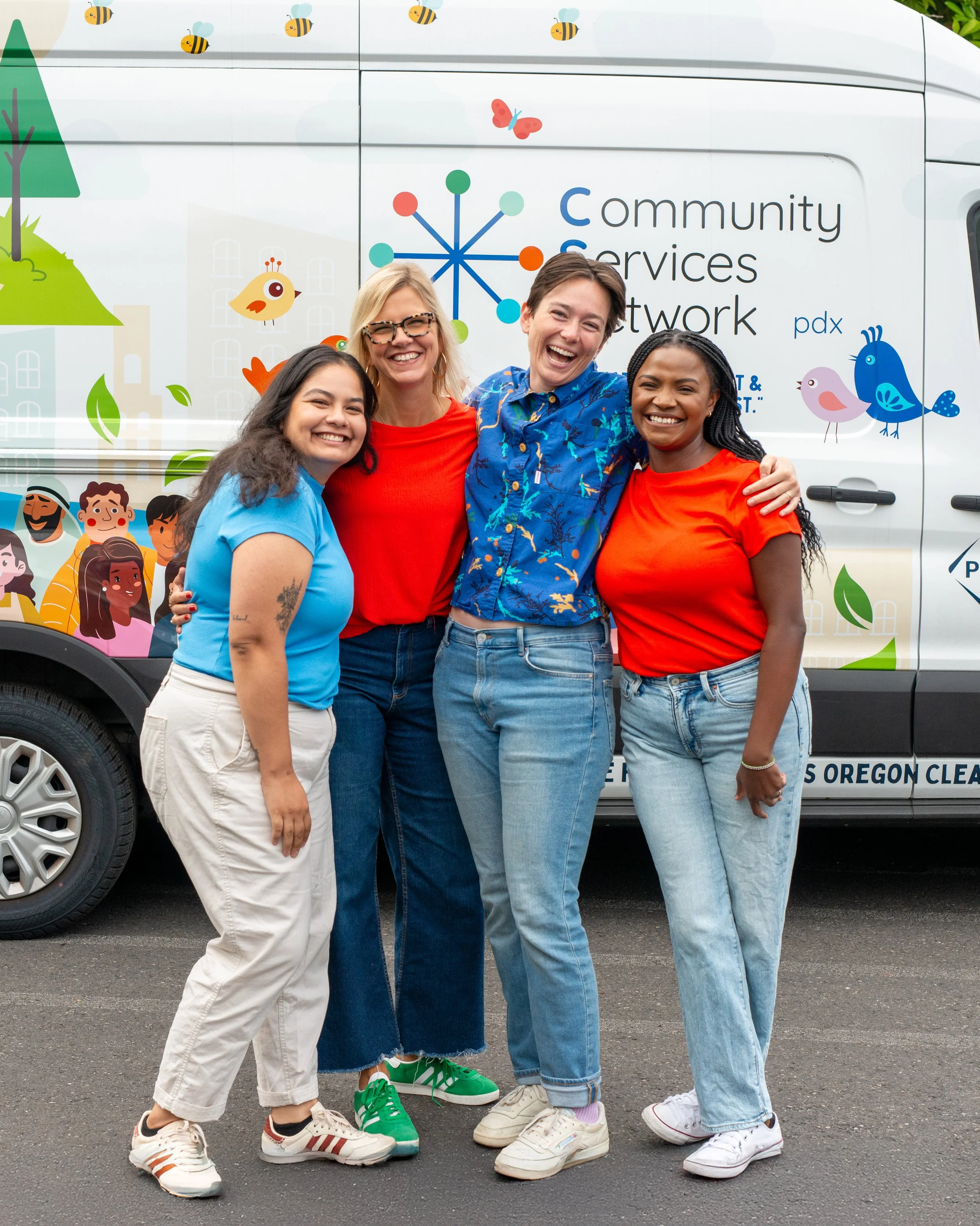 Smiling Community Services Network staff members posing in front of van
