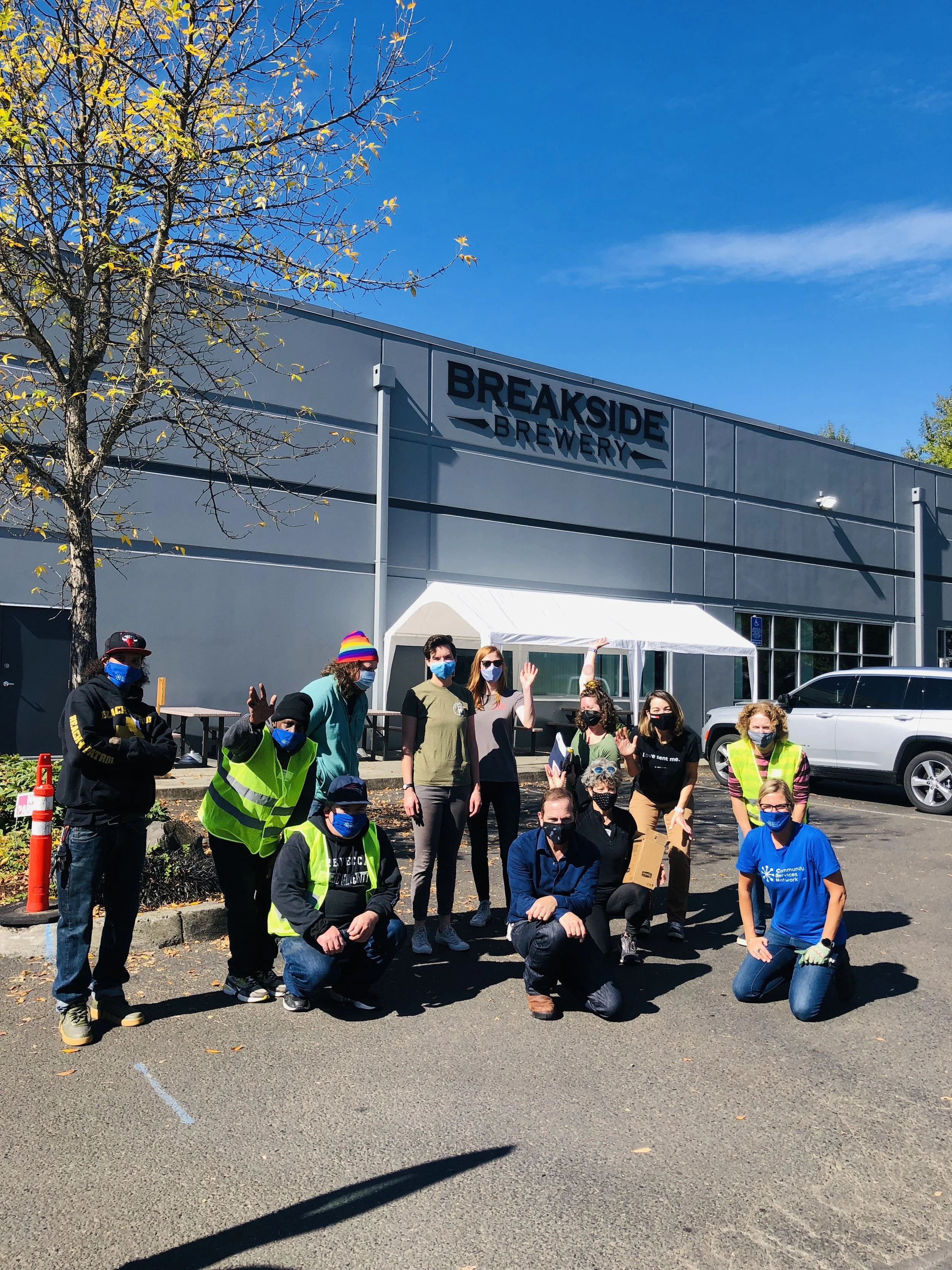  CSN volunteers and partner organization staff posing together outside Breakside Brewery during a community resource fair event in Portland, Oregon. 
