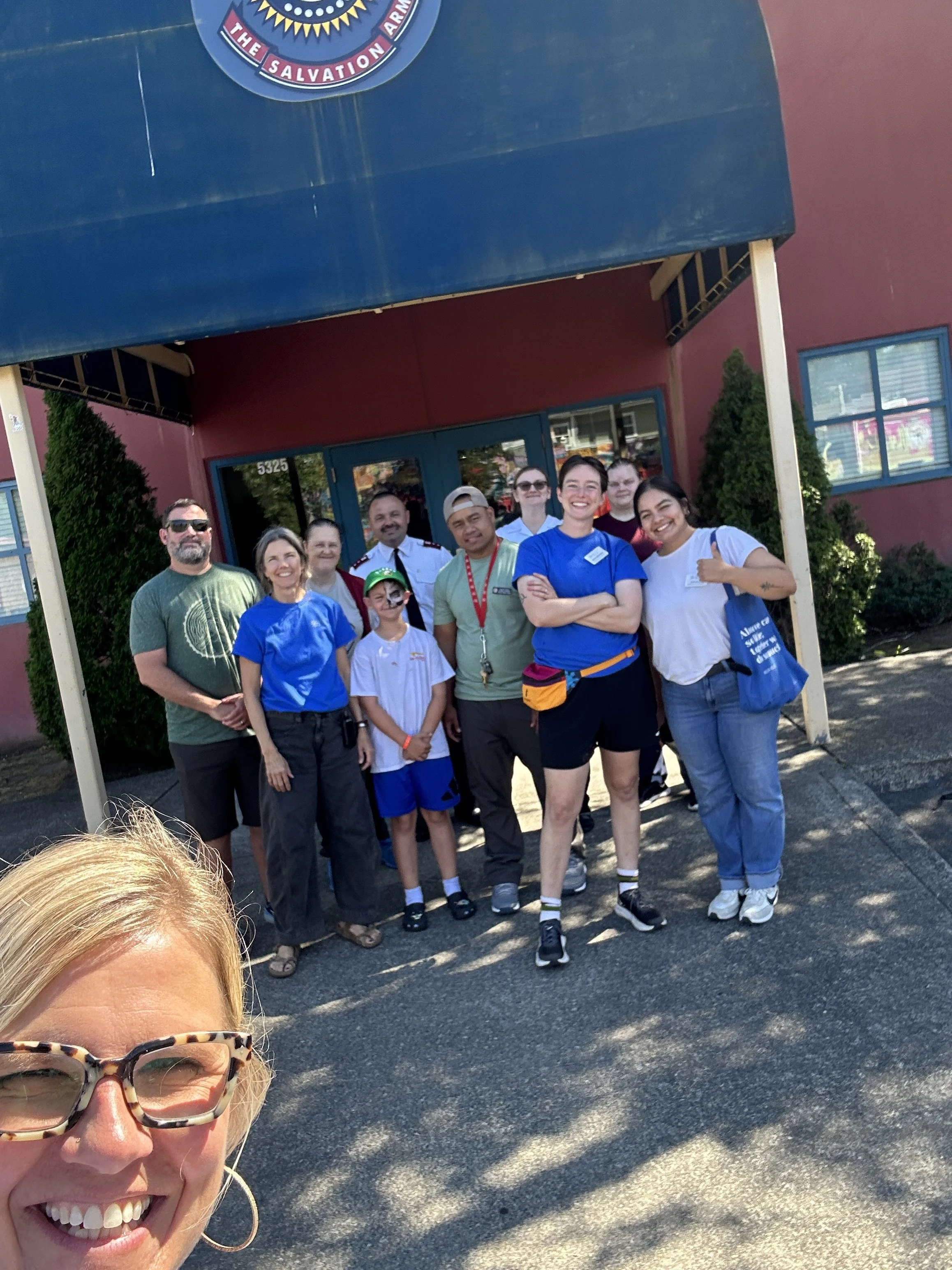  A group of CSN volunteers and partner organization staff posing outside the Salvation Army building at a CSN community resource fair in Portland, Oregon. 