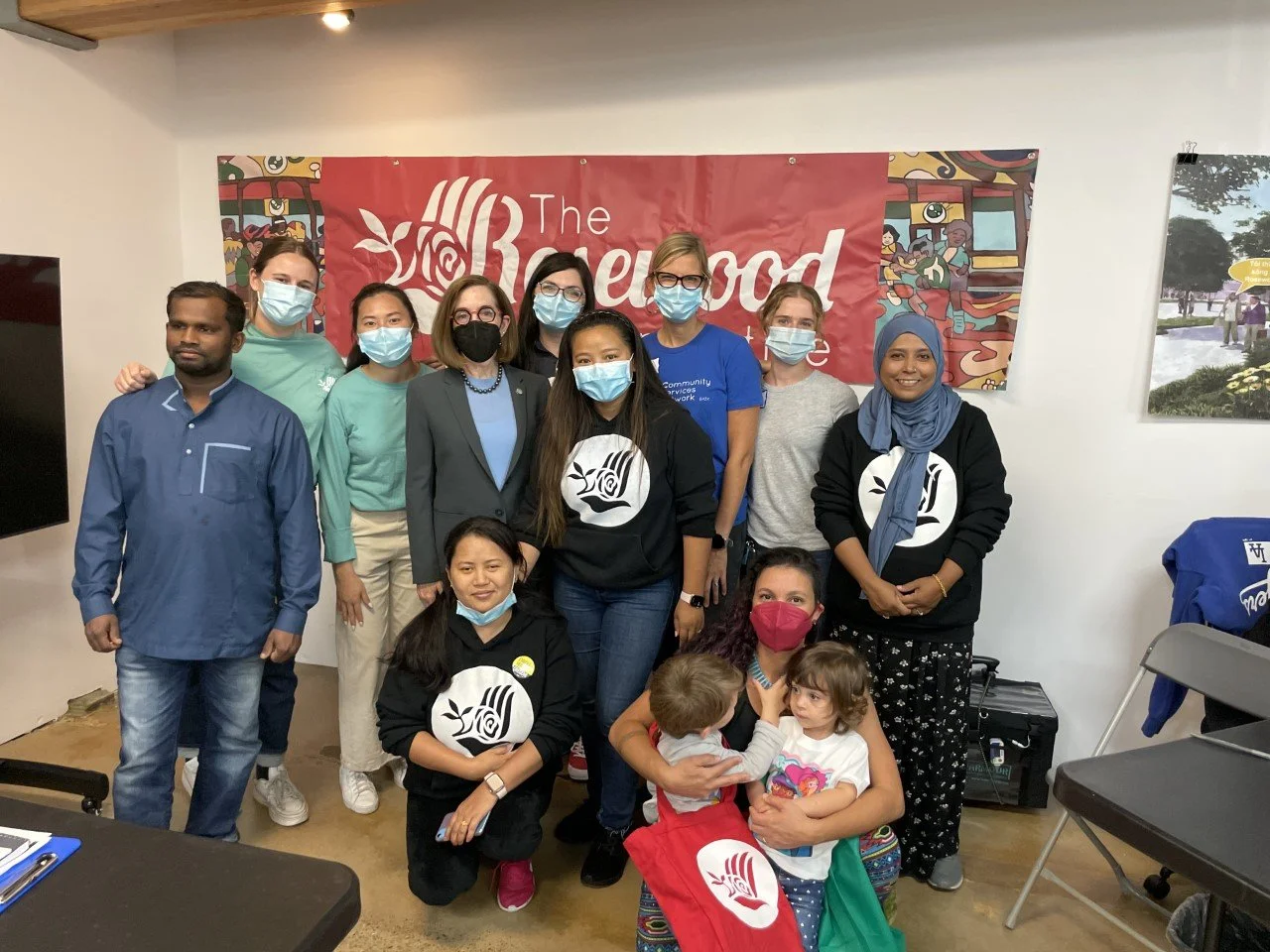  A diverse group of CSN partner organization staff and community members posing in front of The Rosewood Initiative banner at a CSN community resource fair in Portland, Oregon. 