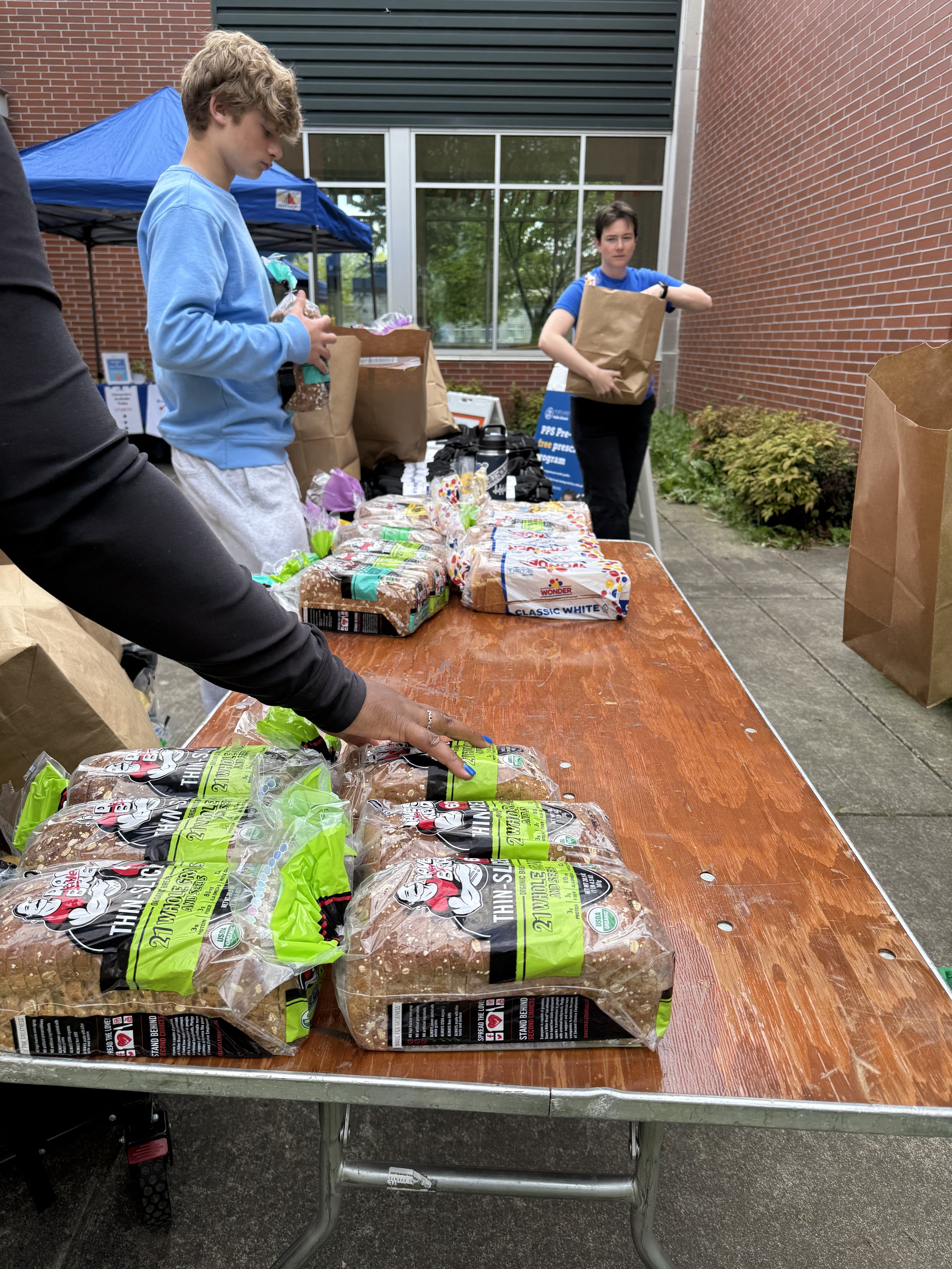  CSN volunteers unloading and organizing bread donations outside a community building during a food distribution resource fair in Portland, Oregon. 