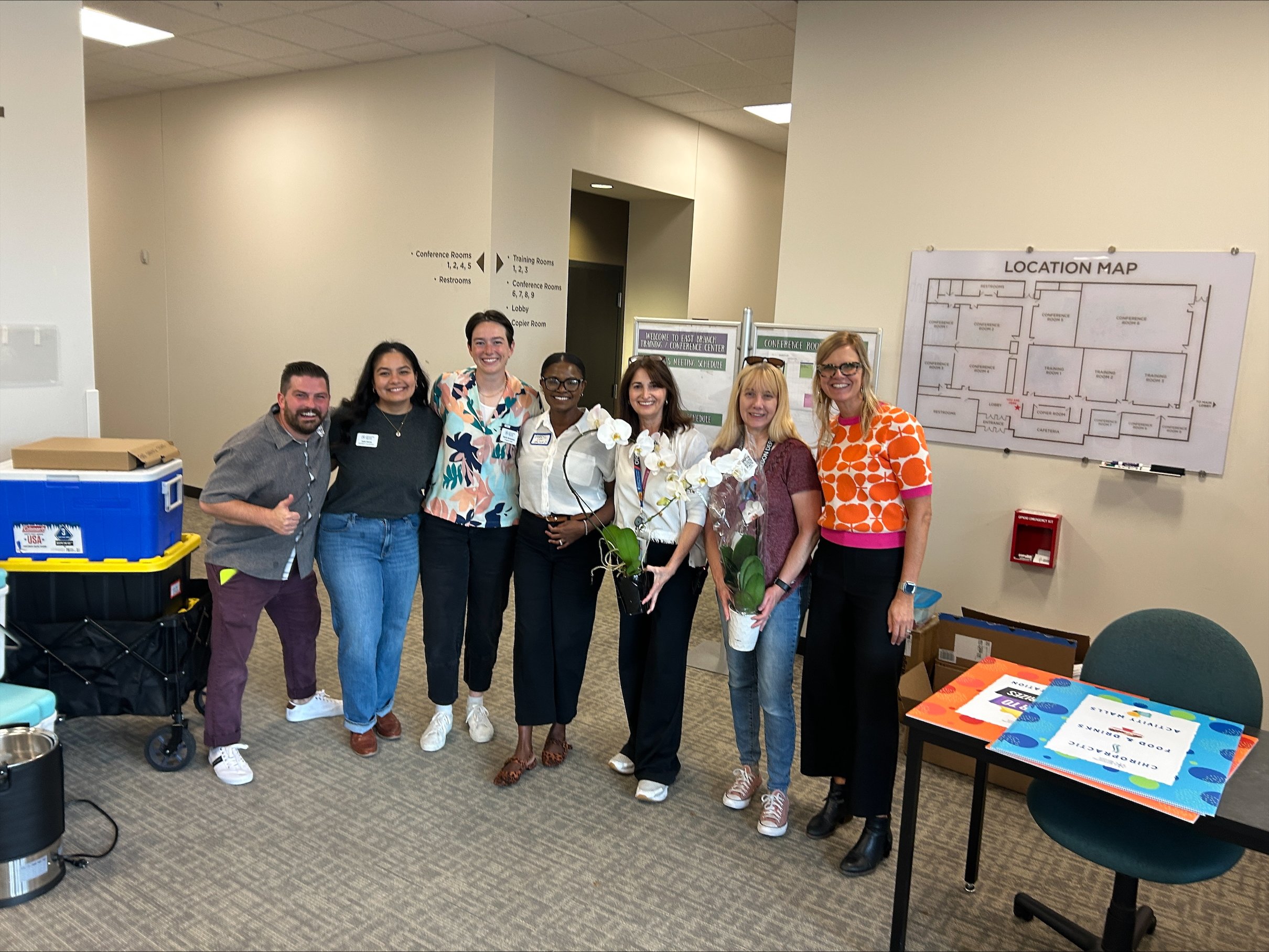  A group of seven CSN event staff and volunteers posing together after setting up a CSN networking event in a conference room in Portland, Oregon. 